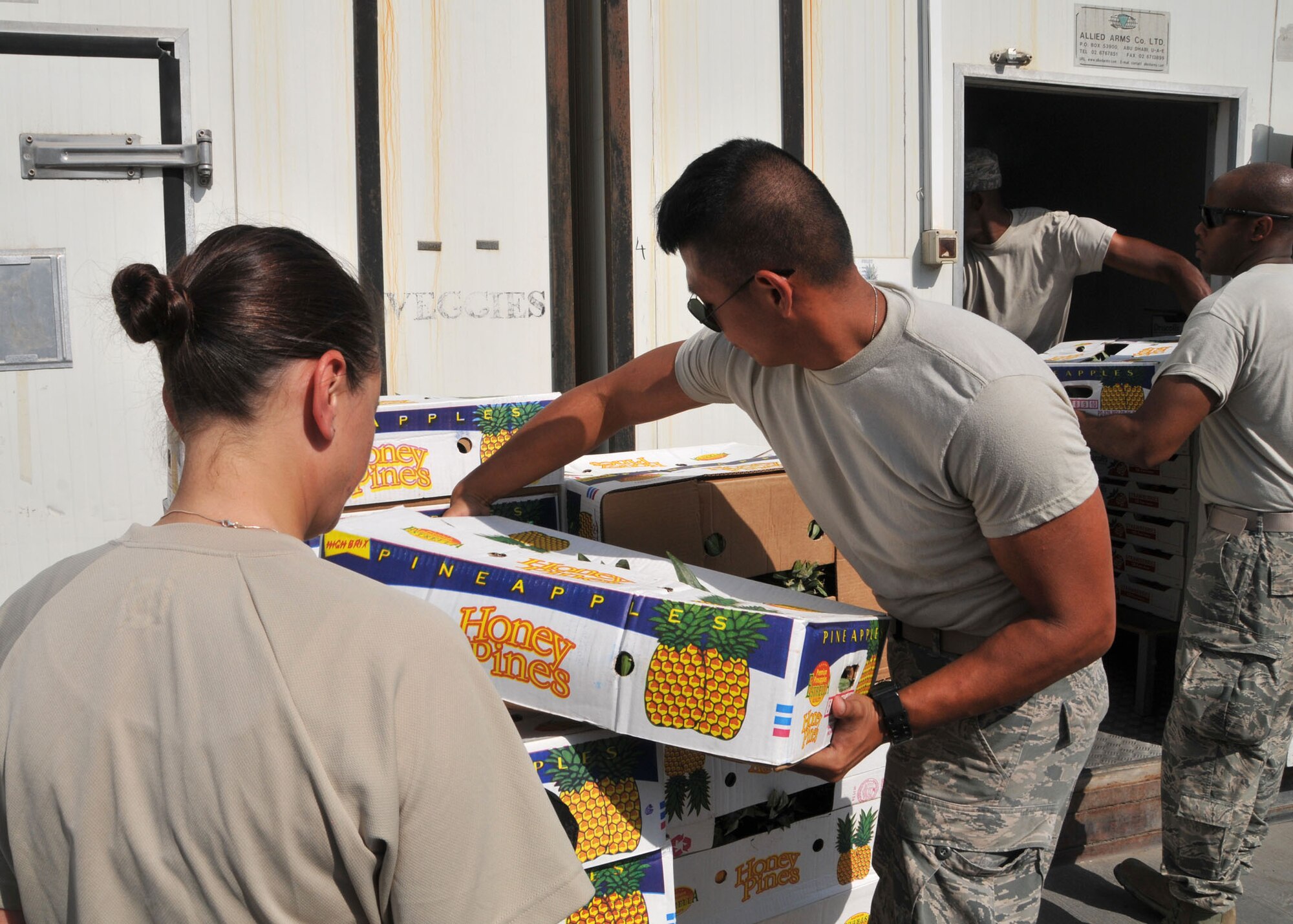 Airmen volunteer to join with dining facility personnel to help load food into refrigerated storage containers at 380th Air Expeditionary Wing Oasis dining facility July 24, 2014. The dining facility personnel depend upon volunteers to assist them with unloading and securing food deliveries to the wing at an undisclosed location in Southwest Asia. (U.S. Air National Guard photo by Senior Master Sgt. Eric Peterson/Released)