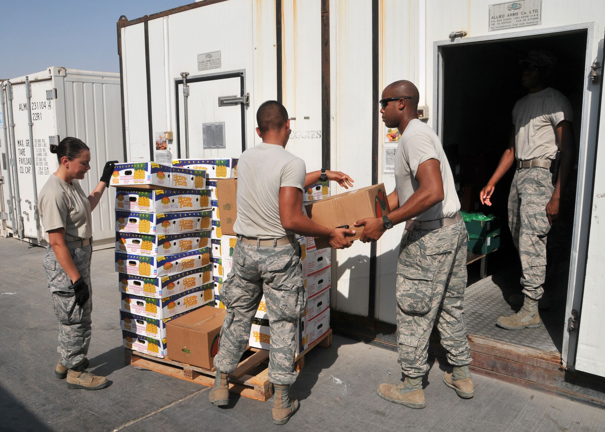 Airmen volunteer to join with dining facility personnel to help load food into refrigerated storage containers at 380th Air Expeditionary Wing Oasis dining facility July 24, 2014. The dining facility personnel depend upon volunteers to assist them with unloading and securing food deliveries to the wing at an undisclosed location in Southwest Asia. (U.S. Air National Guard photo by Senior Master Sgt. Eric Peterson/Released)