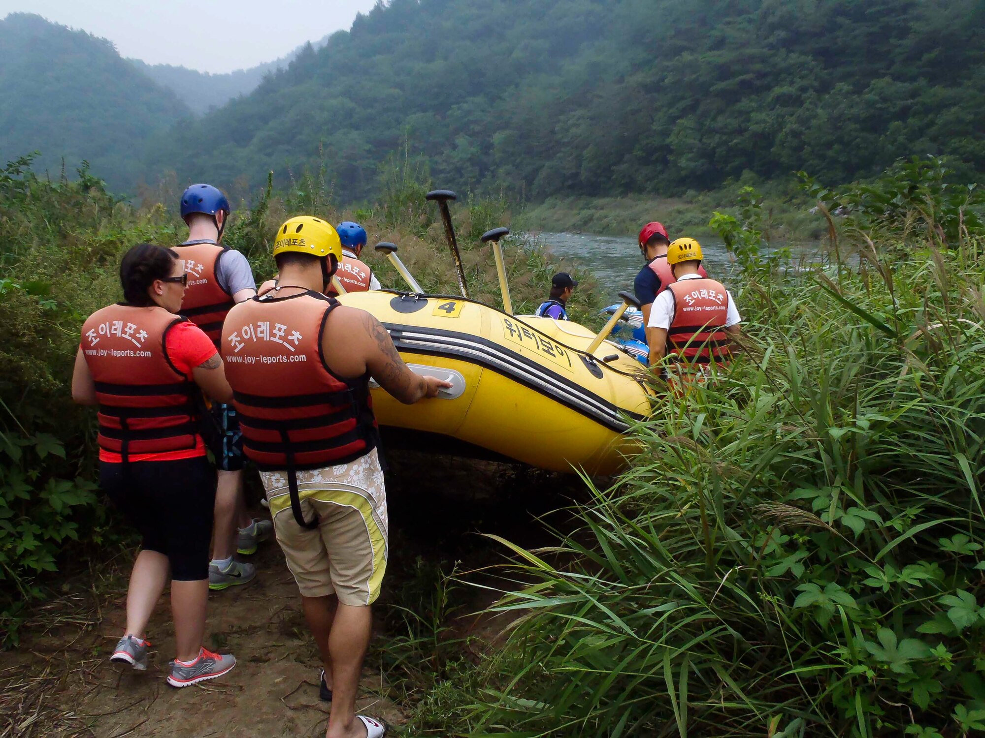 Airmen take a raft to the river during a water rafting trip on the Naerincheon River, Republic of Korea, Aug. 23, 2014. Rafts seat as many as nine people, and basic paddling maneuvers are taught to first time rafters. (U.S. Air Force photo/Senior Airman David Owsianka)