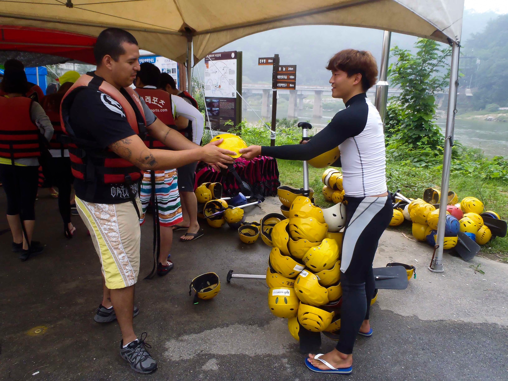 Senior Airman Victor Del Valle Ortega, 51st Logistic Readiness Squadron vehicle operator, receives a helmet before going on a water rafting trip on the Naerincheon River, Republic of Korea, Aug. 23, 2014. Participants also received a life vest and paddle prior to going on the trip. (U.S. Air Force photo/Senior Airman David Owsianka)