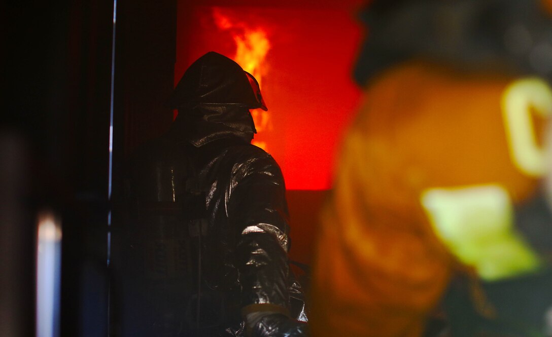 Firefighters and watch as flames crawl up the walls of a fire simulator during an exercise conducted by the Camp Pendleton Fire Department and the Marine Corps Air Station Camp Pendleton’s Aircraft Rescue Fire Fighting unit on a controlled burn training facility at the 25 Area here.
“This is a Flashover simulator,” said Rick Clarke, a train-the-trainer instructor for Fire Training Structures. “This teaches firefighters how to prevent the rapid combustion of off-gas created by burned materials.”
