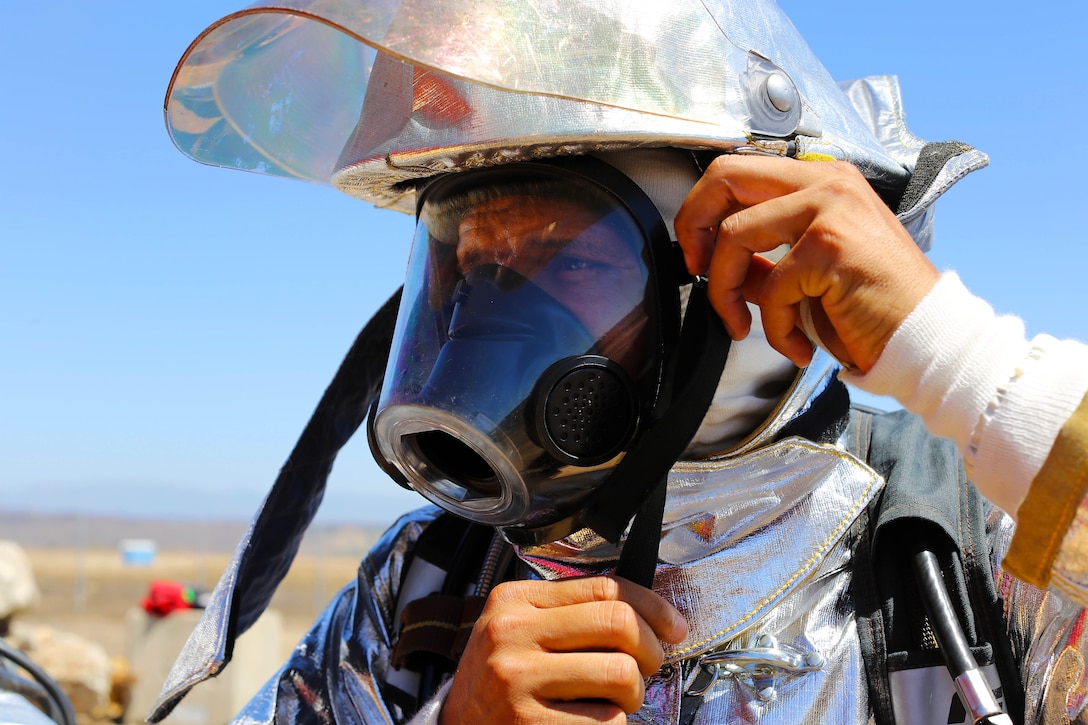 Gunnery Sgt. Jhimelle Sepulveda, training chief with a fire fighting unit here,  dons a flame resistant suit and oxygen tank in preparation for an exercise conducted by the Camp Pendleton Fire Department and the Marine Corps Air Station Camp Pendleton’s Aircraft Rescue Fire Fighting unit on a controlled burn training facility at the 25 Area here.
"This is good training because we don't normally get to experience this type of situation when dealing with burning aircraft," said Sepulveda.
