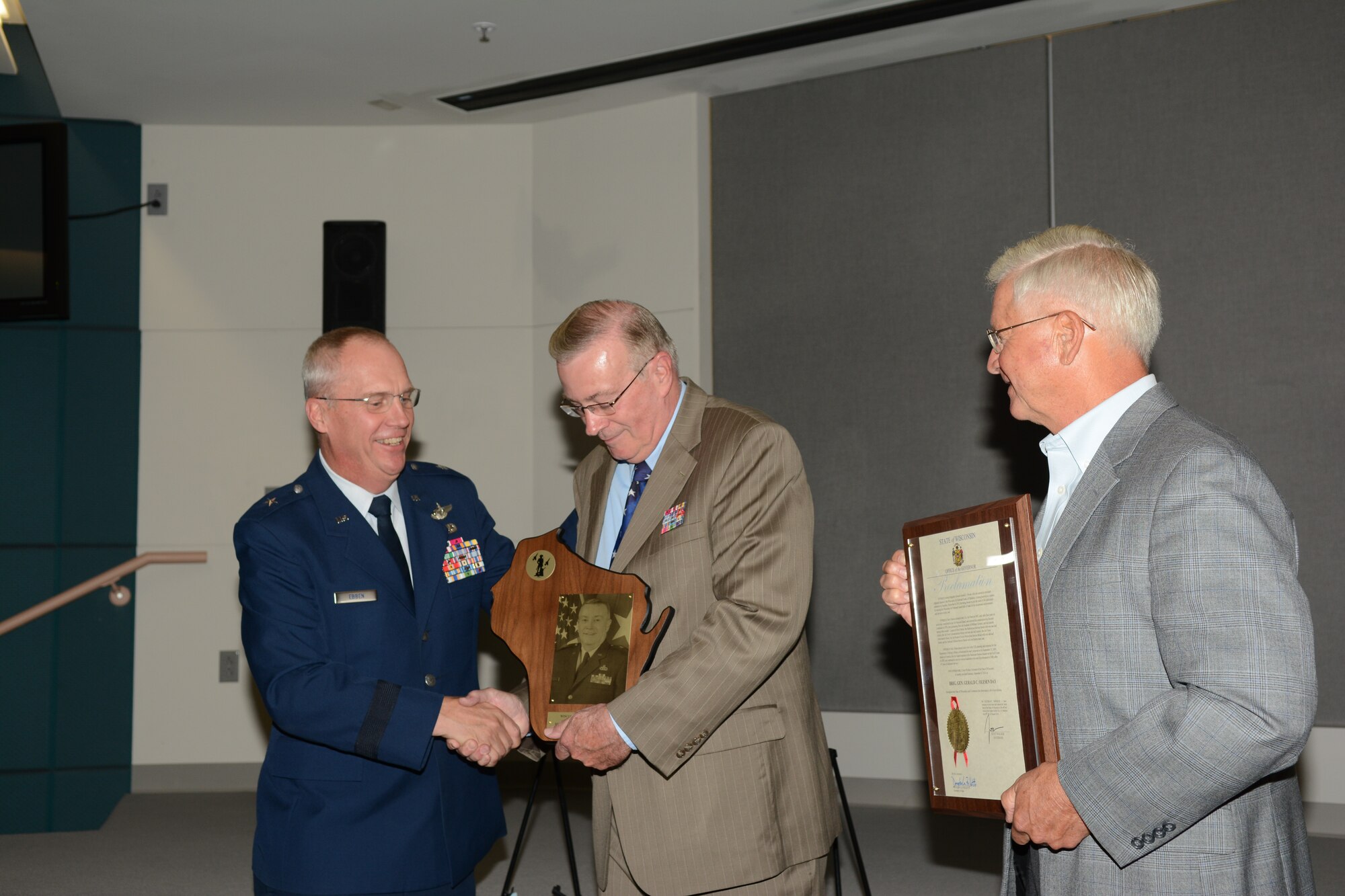 Retired Brig. Gen. Gerald C. Olesen receives the Wisconsin Air National Guard Hall of Fame induction award from Brig. Gen. Gary Ebben, assistant adjutant general for Air, during a Sept. 6 ceremony at Joint Force Headquarters, Madison, Wis. Retired Maj. Gen. Al Wilkening, former Wisconsin adjutant general, was by his side during the presentation. (Air National Guard photo by 1st Lt. Matthew Wunderlin)