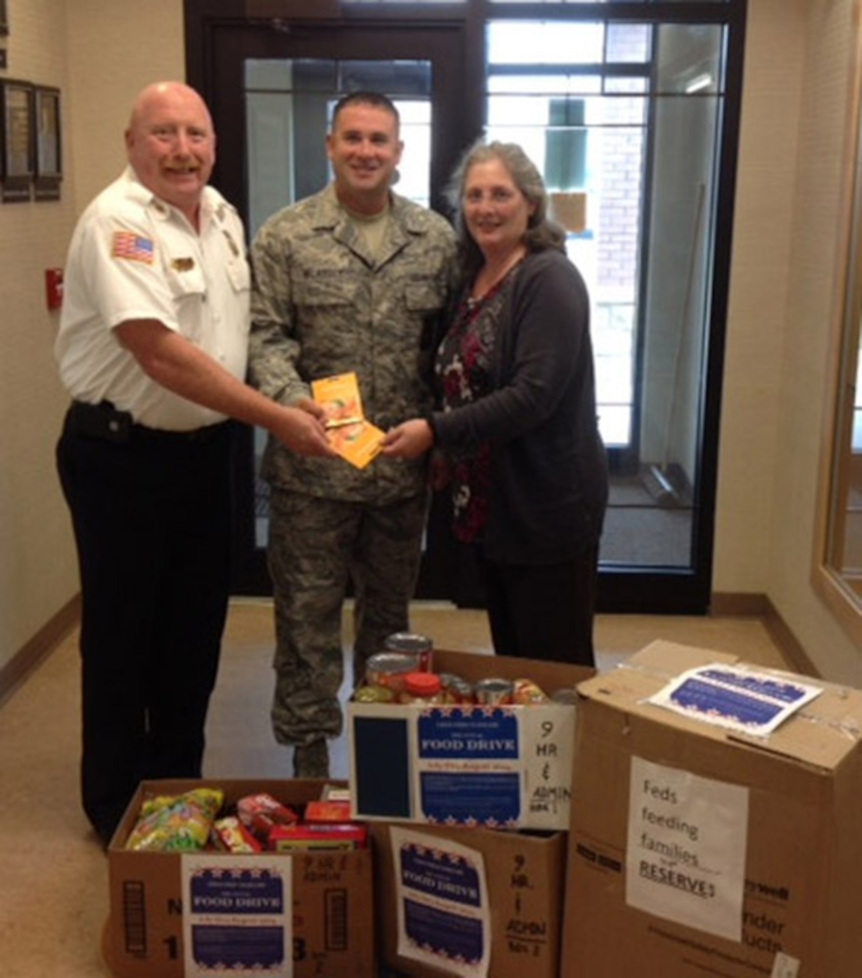 (From left) Niagara Falls Air Reserve Station Fire Department Members Chief Richard Kennerson, Senior Master Sgt. Aaron McArdle and Felecia Redden stand with two local supermarket gift cards and food for donation to the Heart, Love and Soul Inc. Food Pantry and Dining Room located in Niagara Falls, New York on September 5, 2014. While members from different units across the Wing contributed to the cause, the Fire and Emergency Services donated the most food. This outcome was due to a friendly competition within the ranks. (U.S. Air Force photo by Tech. Sgt. Andrew Caya)