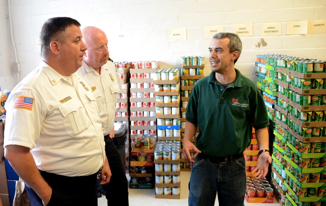 Niagara Falls Air Reserve Station Fire Chief Richard Kennerson, Assistant Chief of Fire Prevention John Schultz, speak with Heart, Love and Soul Inc. Food Pantry and Dining Room Operations and Personnel Manager Michael Daloia in the food pantry store room. Using the program Feds Feed Families, 914th Airlift Wing Airmen and their civilian counterparts donated 315 pounds of food to Heart, Love and Soul Inc. located in Niagara Falls, New York on September 5, 2014.  (U.S. Air Force photo by Tech. Sgt. Andrew Caya)

