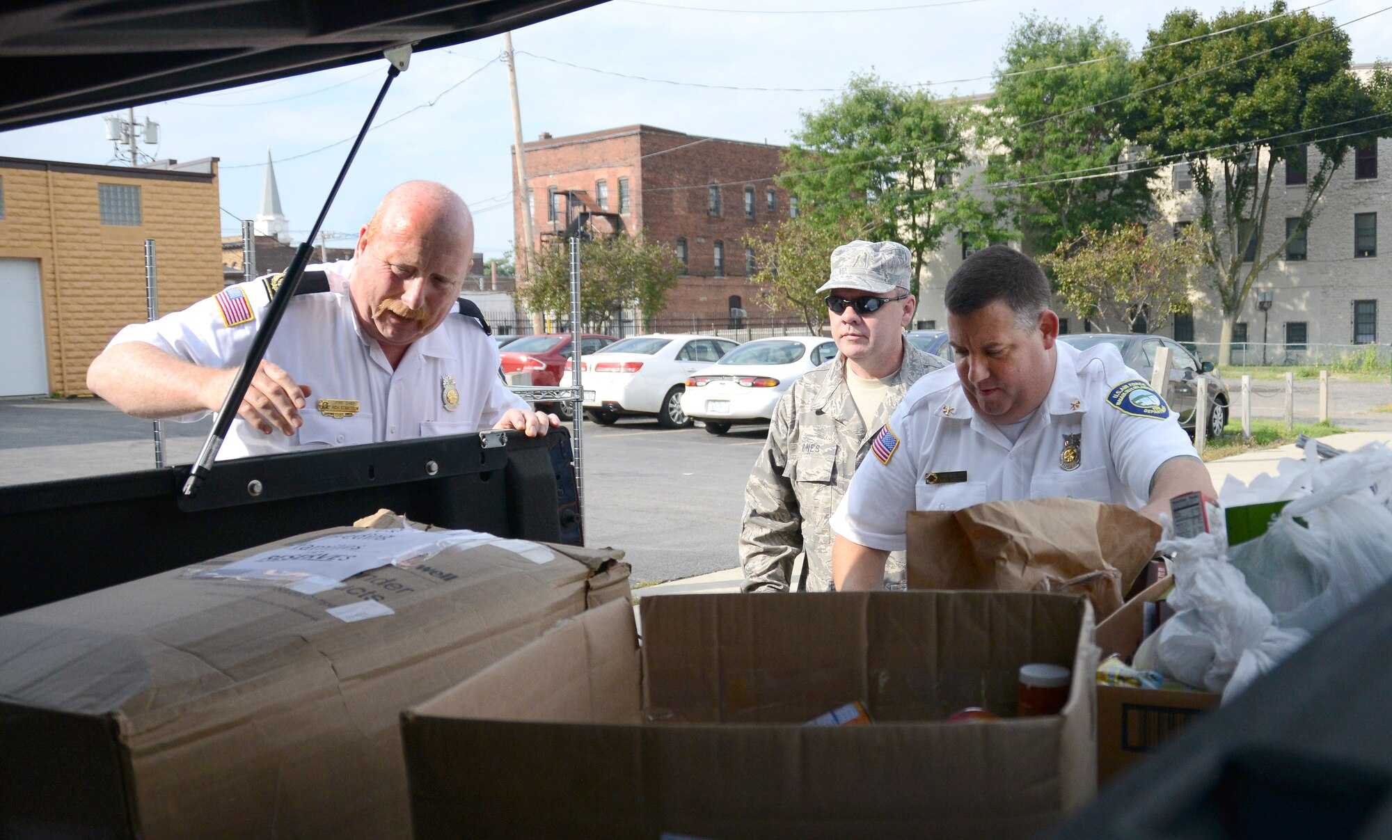 Niagara Falls Air Reserve Station Fire Chief Richard Kennerson, Assistant Chief of Fire Prevention John Schultz, and Chaplain Assistant Tech Sgt. Terry Jones unload food to be donated to Heart, Love and Soul Inc. Food Pantry and Dining Room located in Niagara Falls, New York September 5, 2014.  According to the website of U.S. Department of Agriculture, since the Feds Feed Families campaign began in 2009, Federal workers have donated and collected 24.1 million pounds of food and other non-perishable items to support families across America. (U.S. Air Force photo by Tech. Sgt. Andrew Caya)