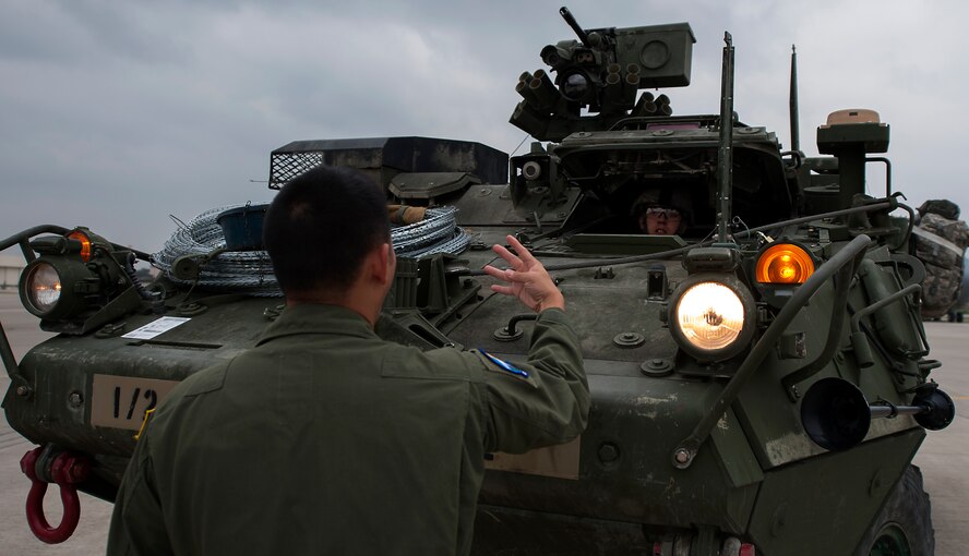 U.S. Air Force Staff Sgt. Quan Vu, 7th Airlift Squadron loadmaster, instructs U.S. Army Private 1st Class Austin Hurrelbrink, 2nd Cavalry Regiment soldier, on proper procedures of loading a Stryker into a C-17 Globemaster III in support of Steadfast Javelin II on Ramstein Air Base, Germany, Sept. 2, 2014. The exercise, Steadfast Javelin II, features a number of dynamic events designed to challenge the multi-national forces in airborne operations, conventional warfare scenarios as well as stability and defensive operations, and support of civil authorities operations. (U.S. Air Force photo/Senior Airman Damon Kasberg)