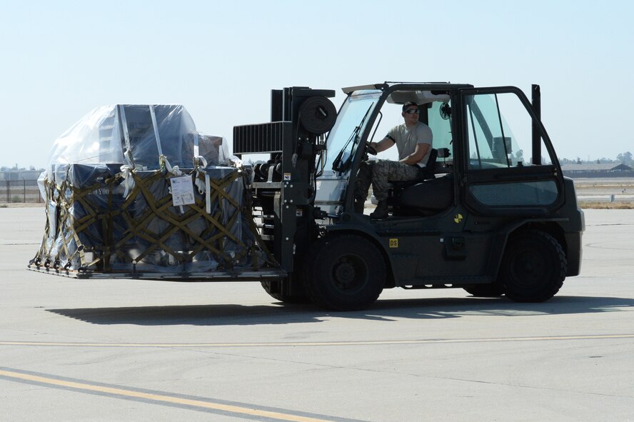 U.S. Air Force Staff Sgt. Ryan Calzada, 144th Logistics Readiness Squadron vehicle mechanic, moves a pallet Sept. 4, 2014. The 144th Fighter Wing is scheduled to attend the Weapons System Evaluation Program in Tyndall AFB, Fla. (Air National Guard photo by Airman 1st Class Klynne Pearl Serrano)