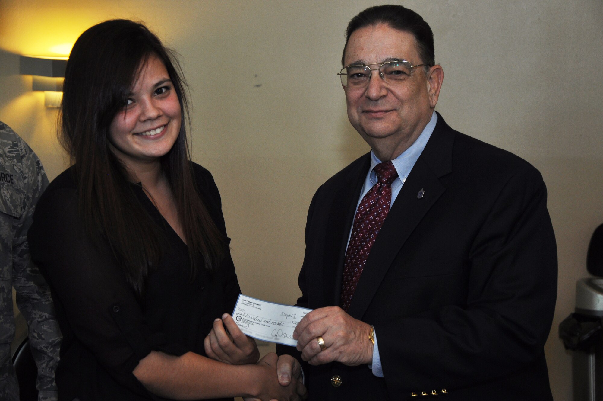 GOODFELLOW AIR FORCE BASE, Texas – Mike Mitchell, Top 3 scholarship funder, presents Senior Airman Hearth Cortes, 17th Security Forces Squadron patrolman, with a $500 check from the Top 3 at the Event Center Sept. 5. Cortes is one of two winners who the Top 3 selected based on their essays. (U.S. Air Force photo illustration/ Senior Airman Joshua Edwards)