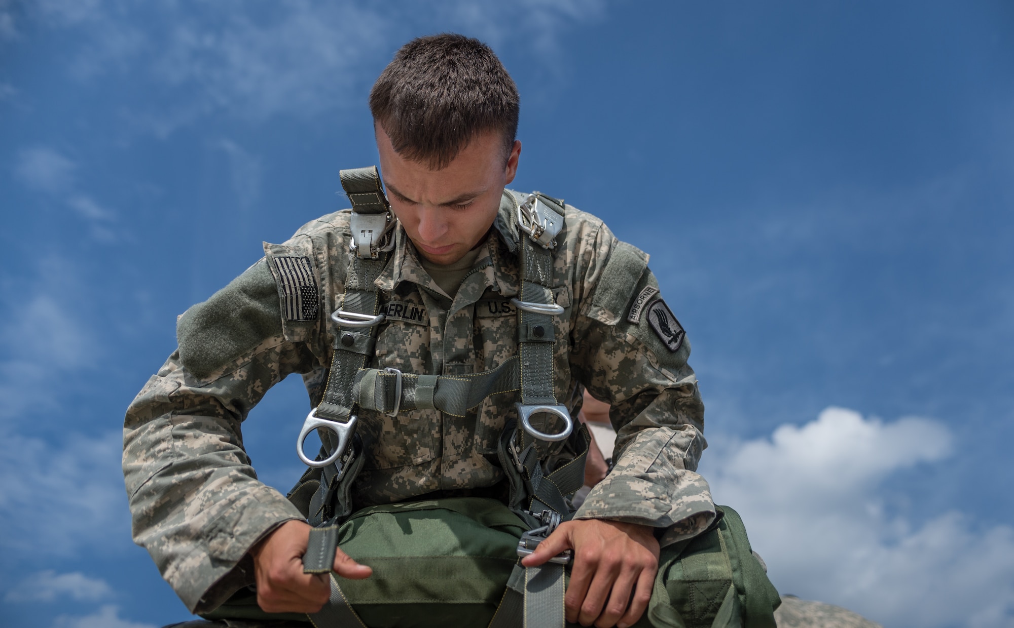 U.S. Army Spc. William Chamberlin, a paratrooper with the 1st Battalion, 503rd Infantry Regiment, 173rd Airborne Brigade dons his parachute before loading into a C-130J Super Hercules during exercise Steadfast Javelin II on Ramstein Air Base, Germany, Sept. 5, 2014. The exercise sustains interoperability between NATO Allies and Partnership for Peace partner nation forces.  The interoperability has been gained during combat and multinational contingency operations over the past seven decades, while focusing on building capacity for the current and future operational environment.(U.S. Air Force photo/Airman 1st Class Jordan Castelan)