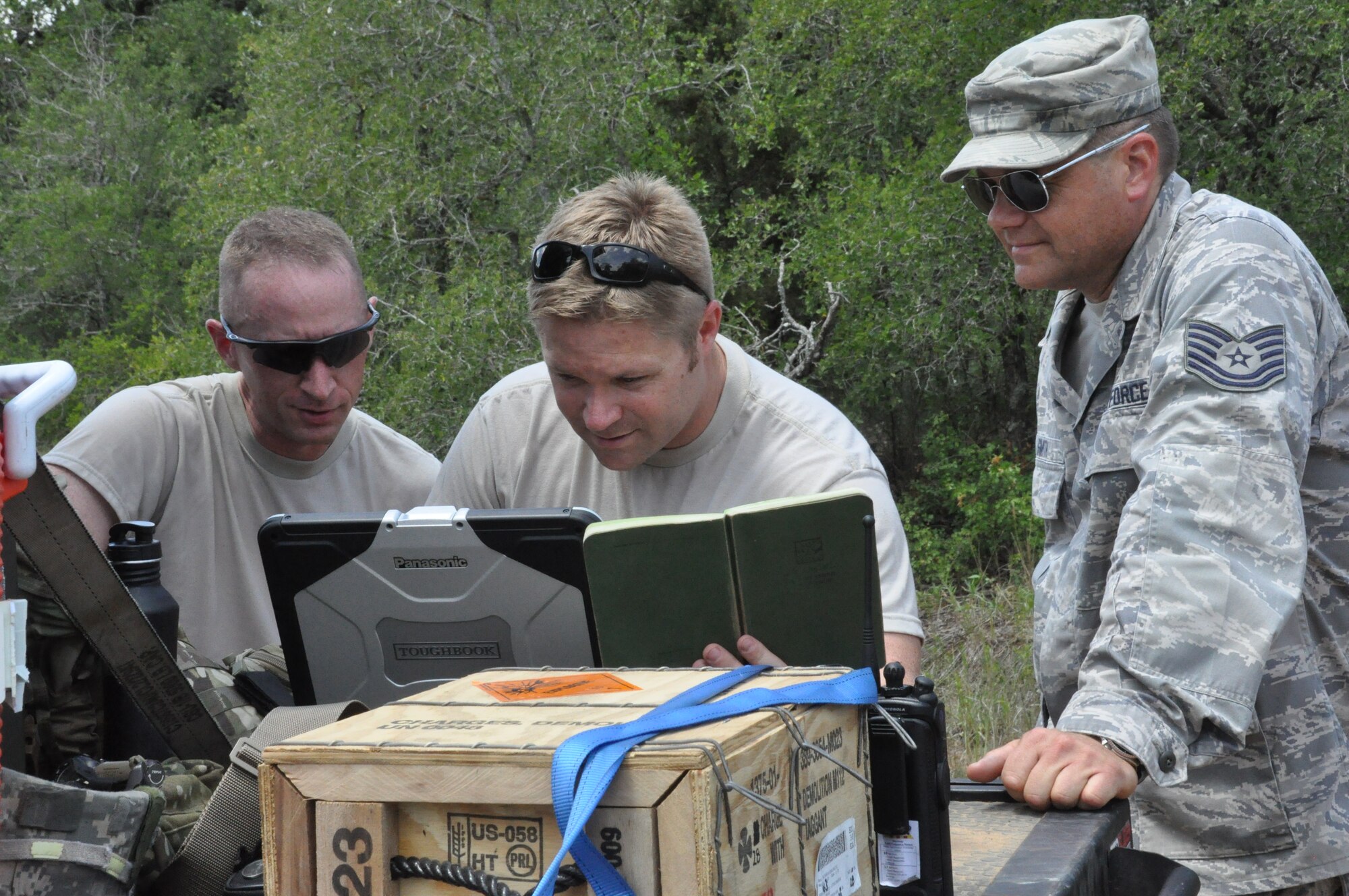 Two members of the 301st EOD team examine images from the report site of an unexploded ordnance at Fort Wolters, TX. (U.S. Air Force photo by Staff Sgt. Jeremy Roman)