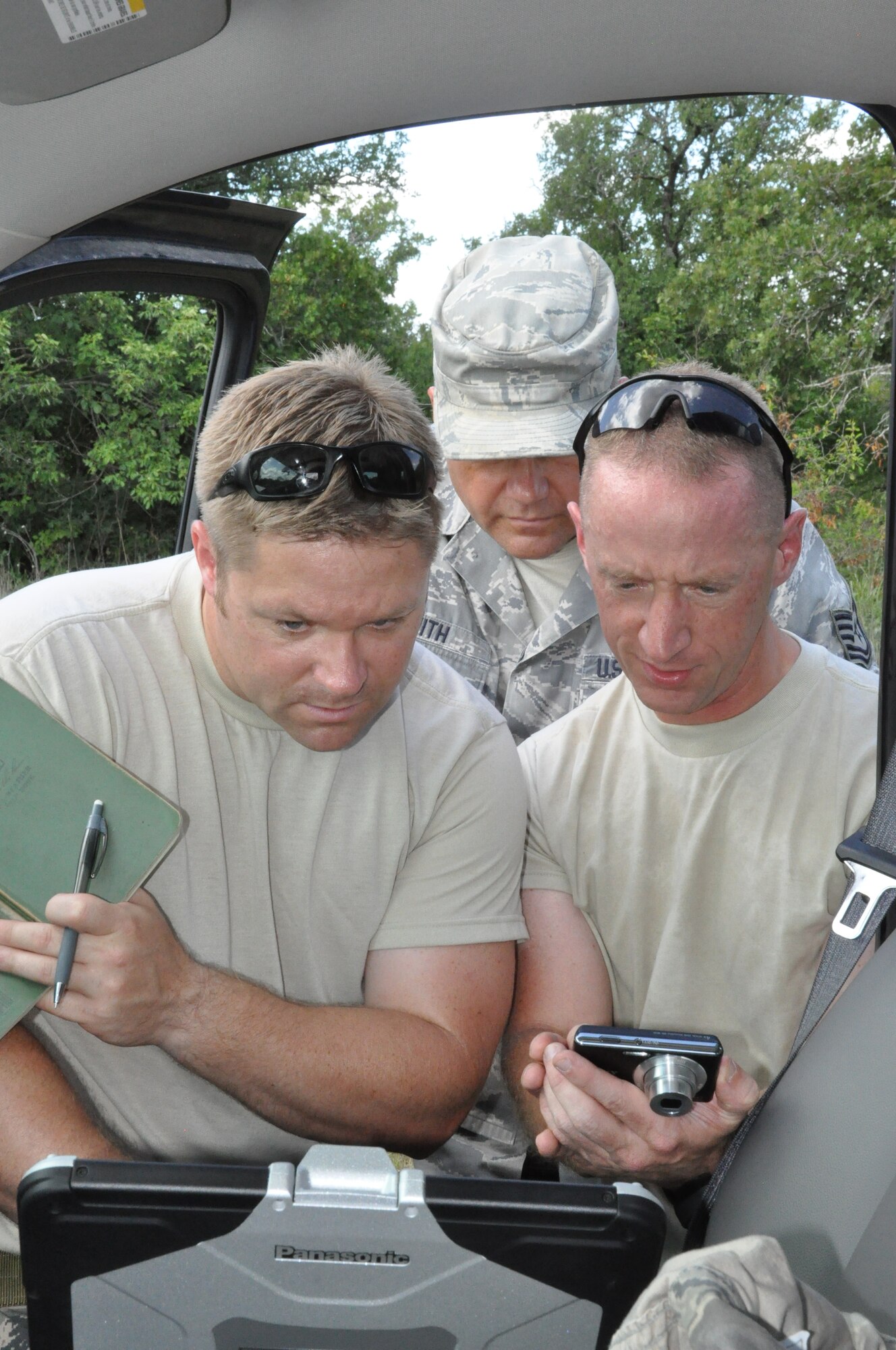 Two members of the 301st EOD team examine images from the report site of an unexploded ordnance at Fort Wolters, TX. (U.S. Air Force photo by Staff Sgt. Jeremy Roman)