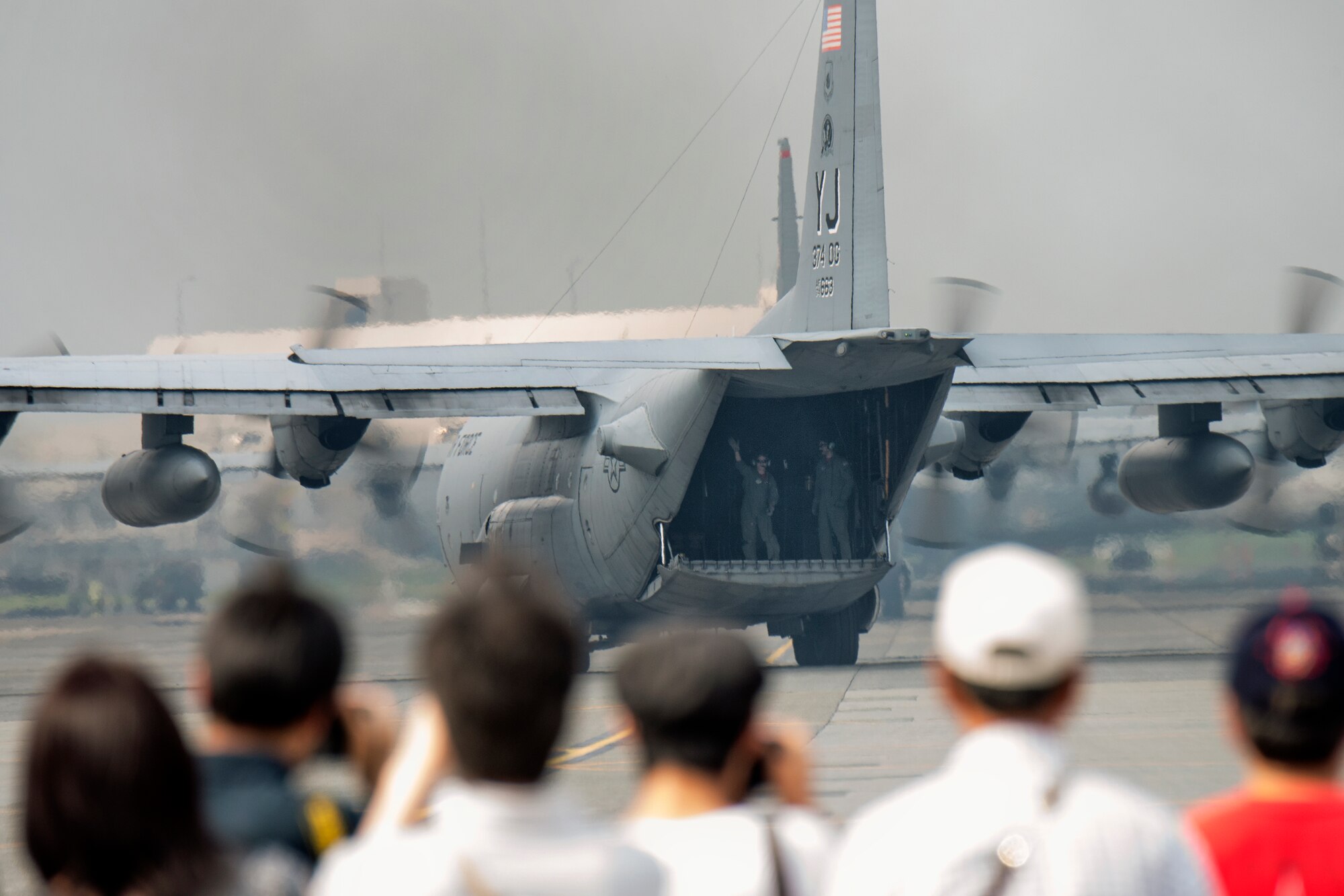 Loadmasters from the 36th Airlift Squadron greet visitors at Yokota Air Base, Japan, during the Japanese-American Friendship Festival Sept. 6, 2014. Airmen from the 36th AS performed C-130 Hercules airdrops. (U.S. Air Force photo by Osakabe Yasuo/Released)