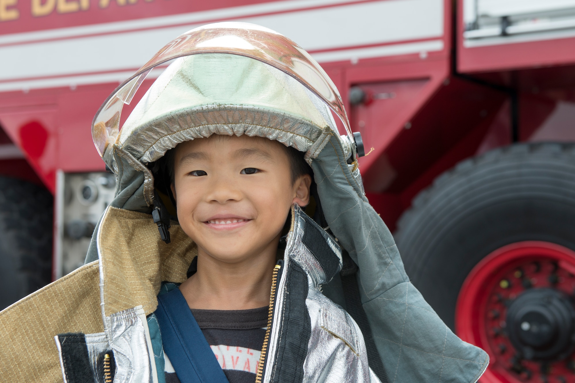 A local boy puts on a firefighting suit for a portrait at Yokota Air Base, Japan, during the Japanese-American Friendship Festival Sept. 7, 2014. Yokota welcomed approximately 148,000 visitors during the two-day festival. (U.S. Air Force photo by Osakabe Yasuo/Released) 