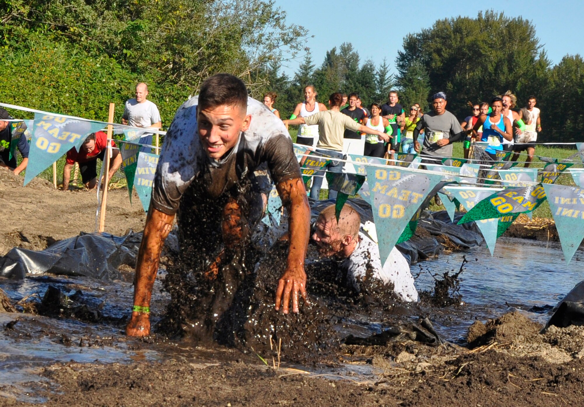 Airman 1st Class Parker Gill (front left) and Senior Airman Kyle Knoblock (front right), both from the 446th Security Forces Squadron, surface from a mud trench during the 2014 Subway Beast Mode Challenge Sept. 6 at Meadowbrook Farm in North Bend, Washington. The 3.5-mile obstacle course and mud run event was sponsored by Air Force Reserve Recruiting, and proceeds went to Fam 1st Foundation, which was co-created by the Seahawks’ own Marshawn Lynch to keep underprivileged youth on a positive path. Gill finished in first place, and Knoblock finished in second place of their wave. (U.S. Air Force Reserve photo by MSgt Minnette Mason)