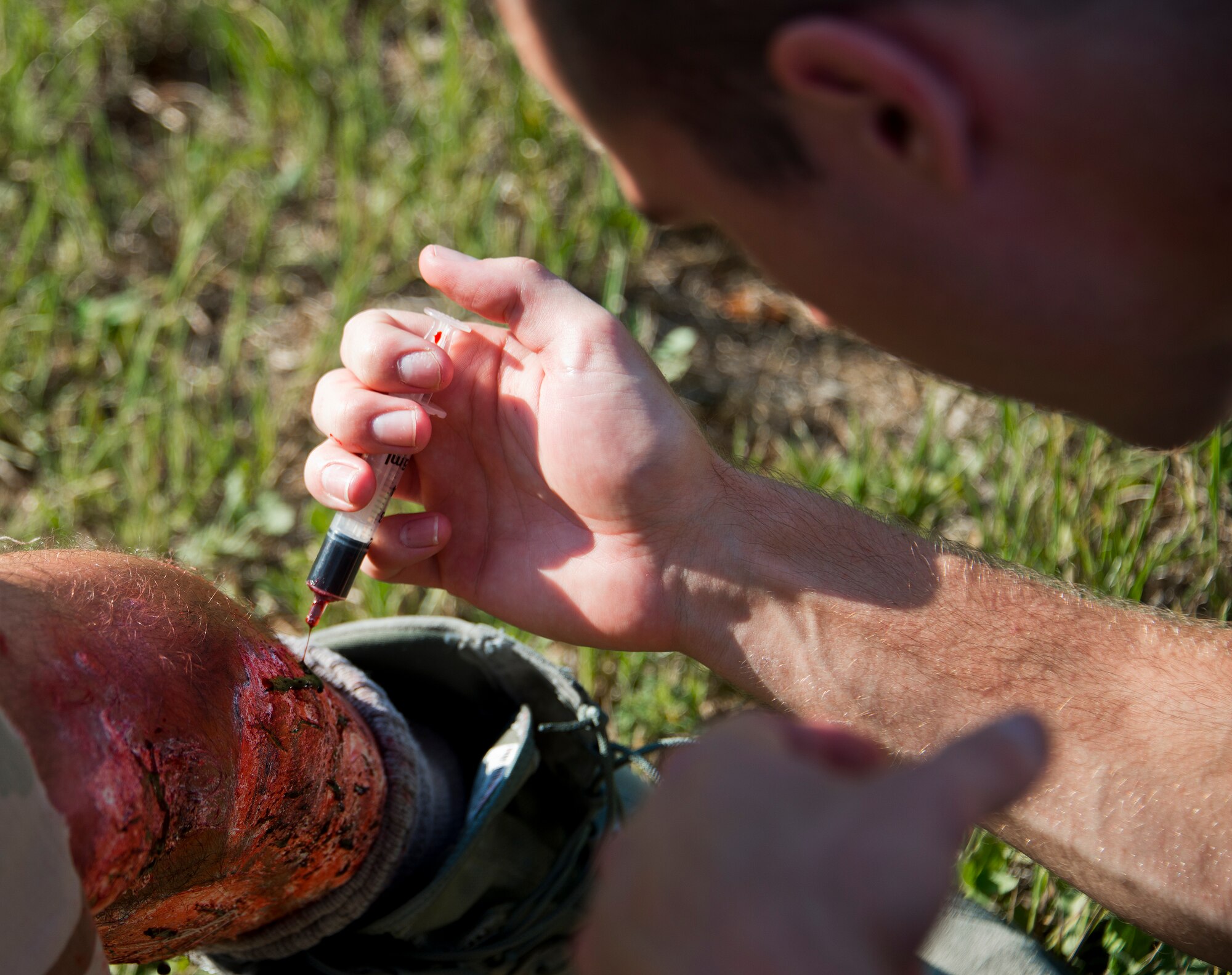 A 96th Medical Group moulage team member applies fake blood to a victim’s leg wound prior to a recent exercise at Duke Field.  The 96th MDG’s team of six Airmen provides a sense of realism in exercises that medics and first responders may encounter in real-world accidents. (U.S. Air Force photo/Tech. Sgt. Jasmin Taylor)