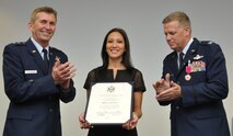 Meilyn Mortensen, wife of Col. Mortensen, deputy director operations and plans at Tenth Air Force, receives a certificate of appreciation during her husband’s retirement ceremony Sep. 6, 2014, Naval Air Station Fort Worth Joint Reserve Base, Texas. Mortensen previously served as vice-commander of the 301st Fighter Wing from 2008 to 2010. (U.S. Air Force photo by Staff Sgt. Samantha Mathison)
