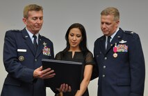 Meilyn Mortensen, wife of Col. Mortensen, deputy director operations and plans at Tenth Air Force, receives a certificate of appreciation during her husband’s retirement ceremony Sep. 6, 2014, Naval Air Station Fort Worth Joint Reserve Base, Texas. Mortensen previously served as vice-commander of the 301st Fighter Wing from 2008 to 2010. (U.S. Air Force photo by Staff Sgt. Samantha Mathison)