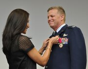 Col. Robert Mortensen, deputy director operations and plans at Tenth Air Force, smiles as his wife attaches his retirement pin Sep. 6, 2014, Naval Air Station Fort Worth Joint Reserve Base, Texas. He previously served as vice-commander of the 301st Fighter Wing from 2008 to 2010. (U.S. Air Force photo by Staff Sgt. Samantha Mathison)