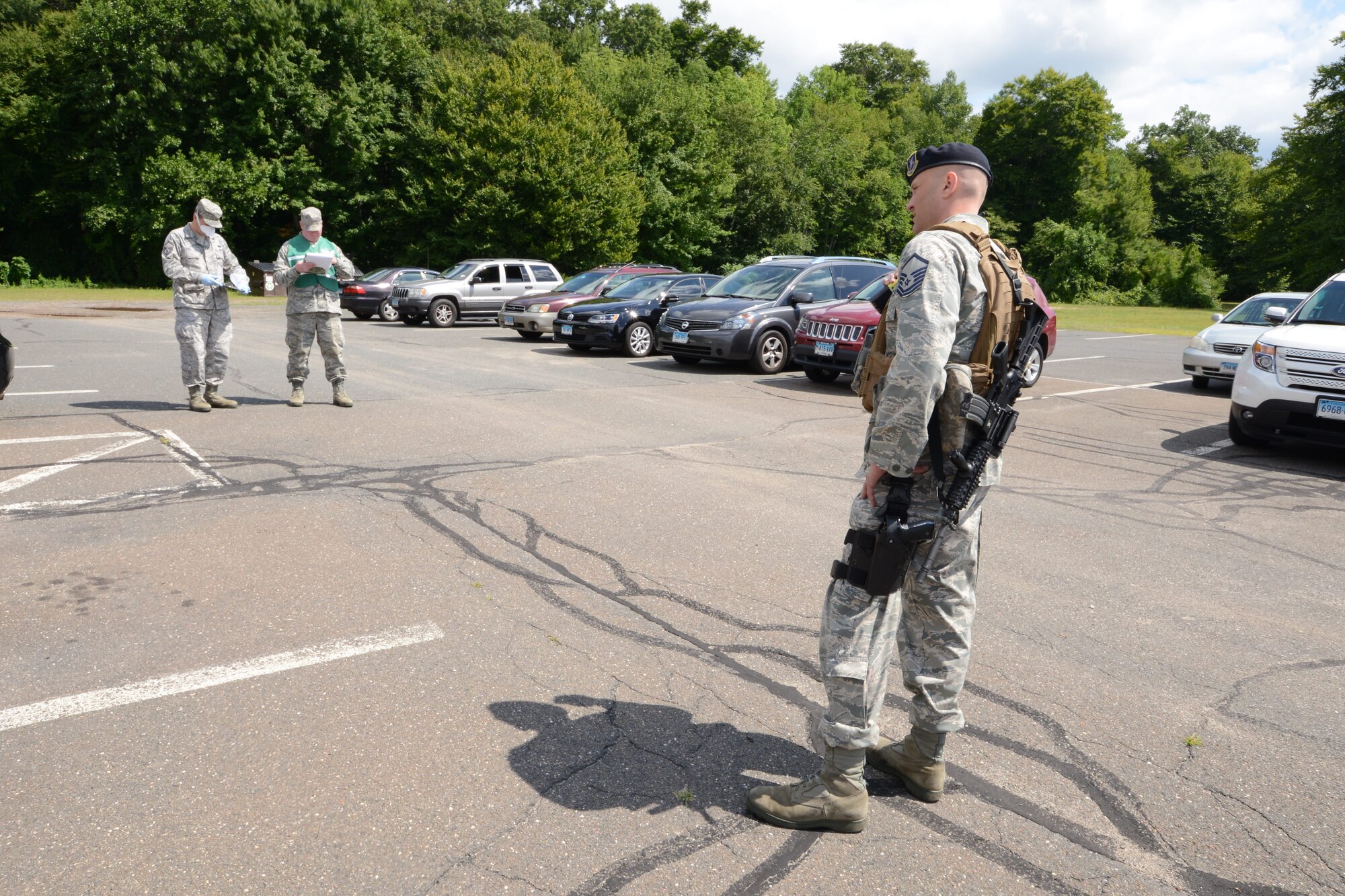 Master Sgt. Christopher Redo, a member of the 103rd Security Forces Squadron, keeps Master Sgt. Kevin Ruel, knowledge operations manager with the 103rd Operations Group, isolated to prevent simulated contamination as Senior Master Sgt. Mark Cote, a member of the wing’s inspection team, observes procedures during the wing’s annual suspicious package exercise at Bradley Air National Guard Base, East Granby, Conn., Aug. 14, 2014.  (U.S. Air National Guard photo by Master Sgt. Erin McNamara)