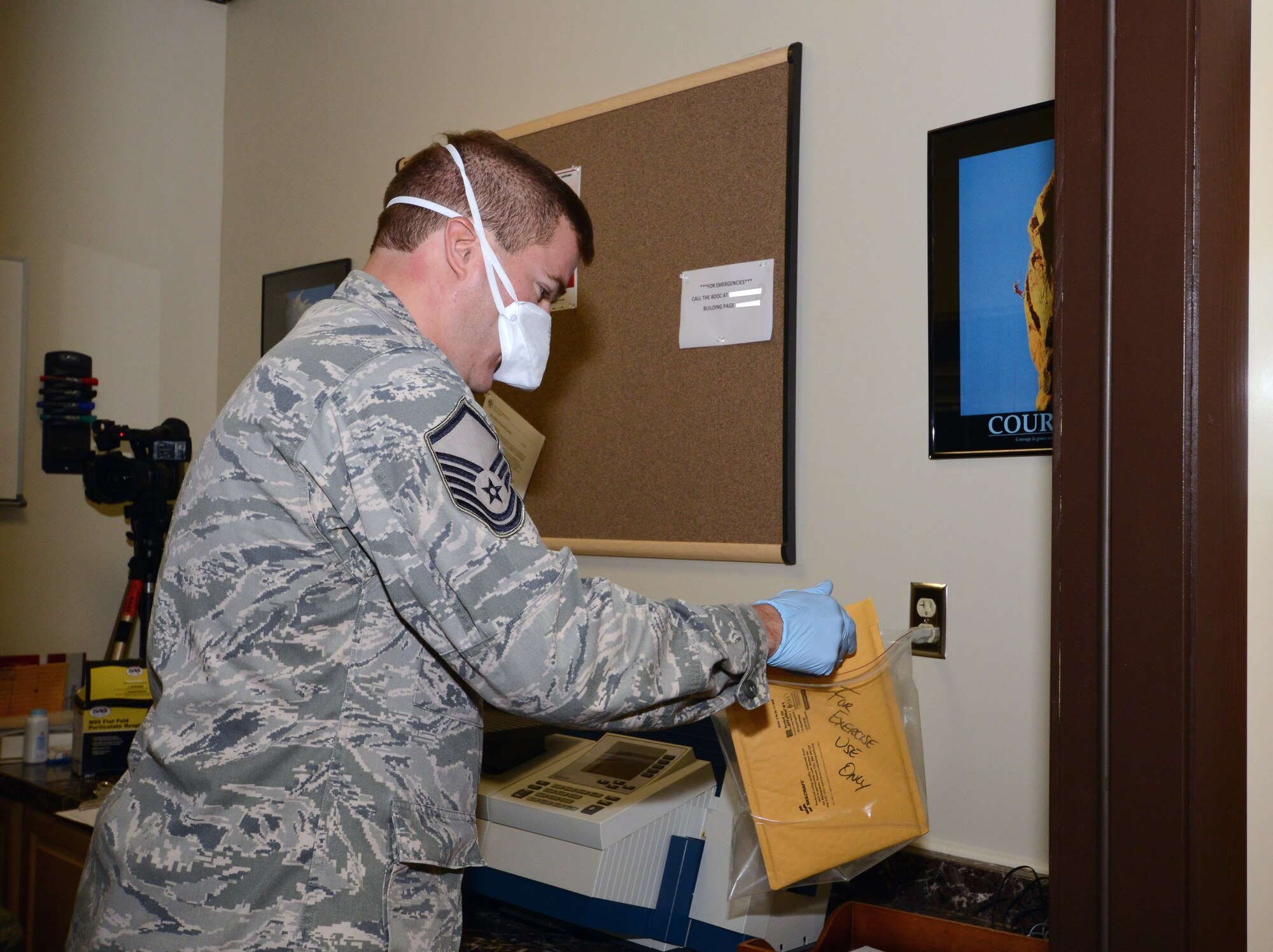 Master Sgt. Kevin Ruel, knowledge operations manager with the 103rd Operations Group, works to contain a simulated suspicious package identified in the base mail distribution center during the wing’s annual suspicious package exercise at Bradley Air National Guard Base, East Granby, Conn., Aug. 14, 2014.   (U.S. Air National Guard photo by Master Sgt. Erin McNamara)