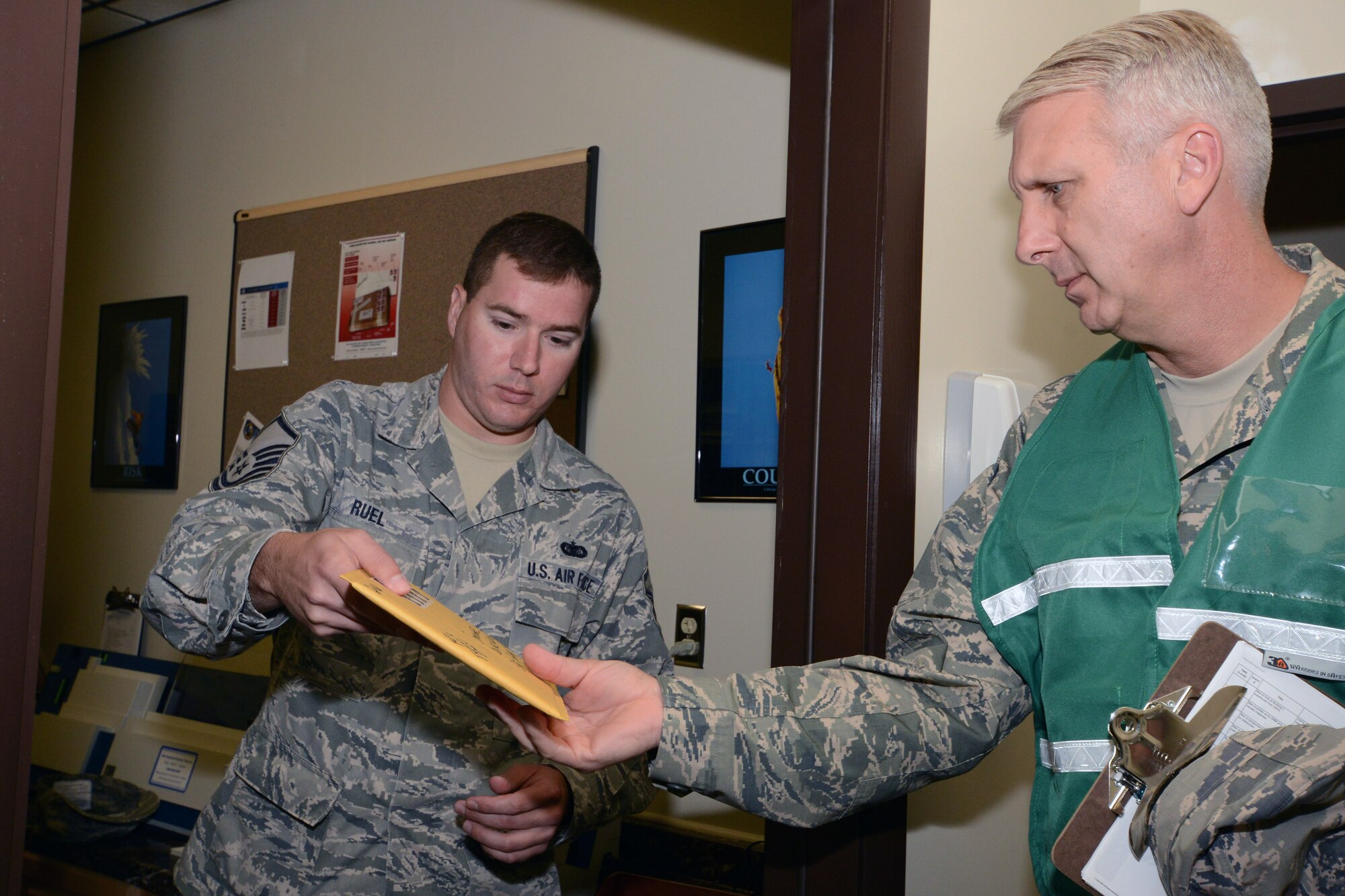 Master Sgt. Kevin Ruel, knowledge operations manager with the 103rd Operations Group, identifies a package containing a simulated hazardous material and points out indicators common to real-world suspicious packages to Lt. Col. James Guerrera of the 103rd Airlift Wing’s inspector general’s office during the wing’s annual suspicious package exercise at Bradley Air National Guard Base, East Granby, Conn., Aug. 14, 2014.  (U.S. Air National Guard photo by Master Sgt. Erin McNamara)