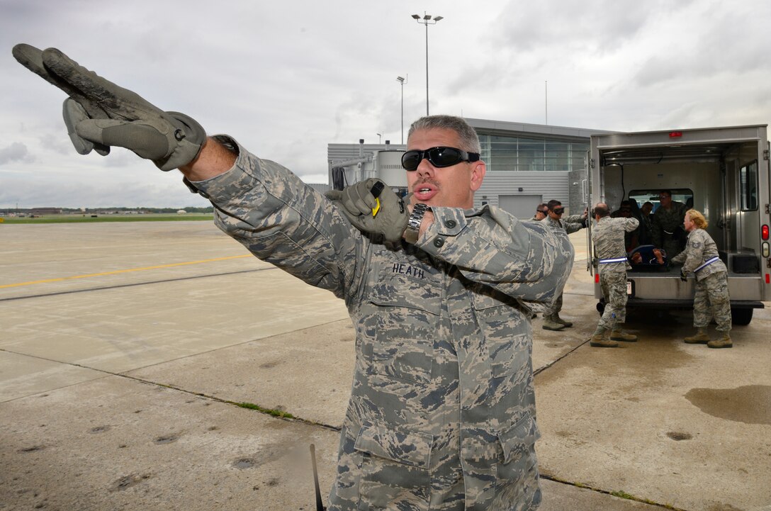 Master Sgt. Joseph Heath, 914th Aeromedical Staging Squadron, signals to Aeromedical Evacuation Technicians during Operation Cold Front, here at Niagara Falls Air Reserve Station, September 6, 2014.This exercise serves as an opportunity to evaluate participants on their ability to respond to operational needs and demonstrate mission execution capabilities.  (U.S. Air Force photo by Staff Sgt. Stephanie Clark)
