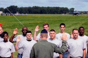 Col. Philip R. Sheridan, 127th Wing commander, swears in more than a dozen people as new members of the Michigan Air National Guard during a ceremony at the 2014 Selfridge Open House & Air Show, Sept. 6, 2014. The new Airmen will serve in various capacities in the 1,700-member 127th Wing, which is based at Selfridge Air National Guard Base, Mich. (U.S. Air National Guard photo by Master Sgt. David Kujawa)
