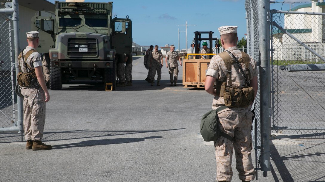 Marines stand guard at a warehouse during exercise Ulchi Freedom Guardian Aug. 22 at Camp Kinser. The Marines are training for real combat situations in the Asia-Pacific region by checking for security badges, security access levels and searching all bags entering the grounds. The Marines are with 3rd Marine Logistics Group, III Marine Expeditionary Force. 