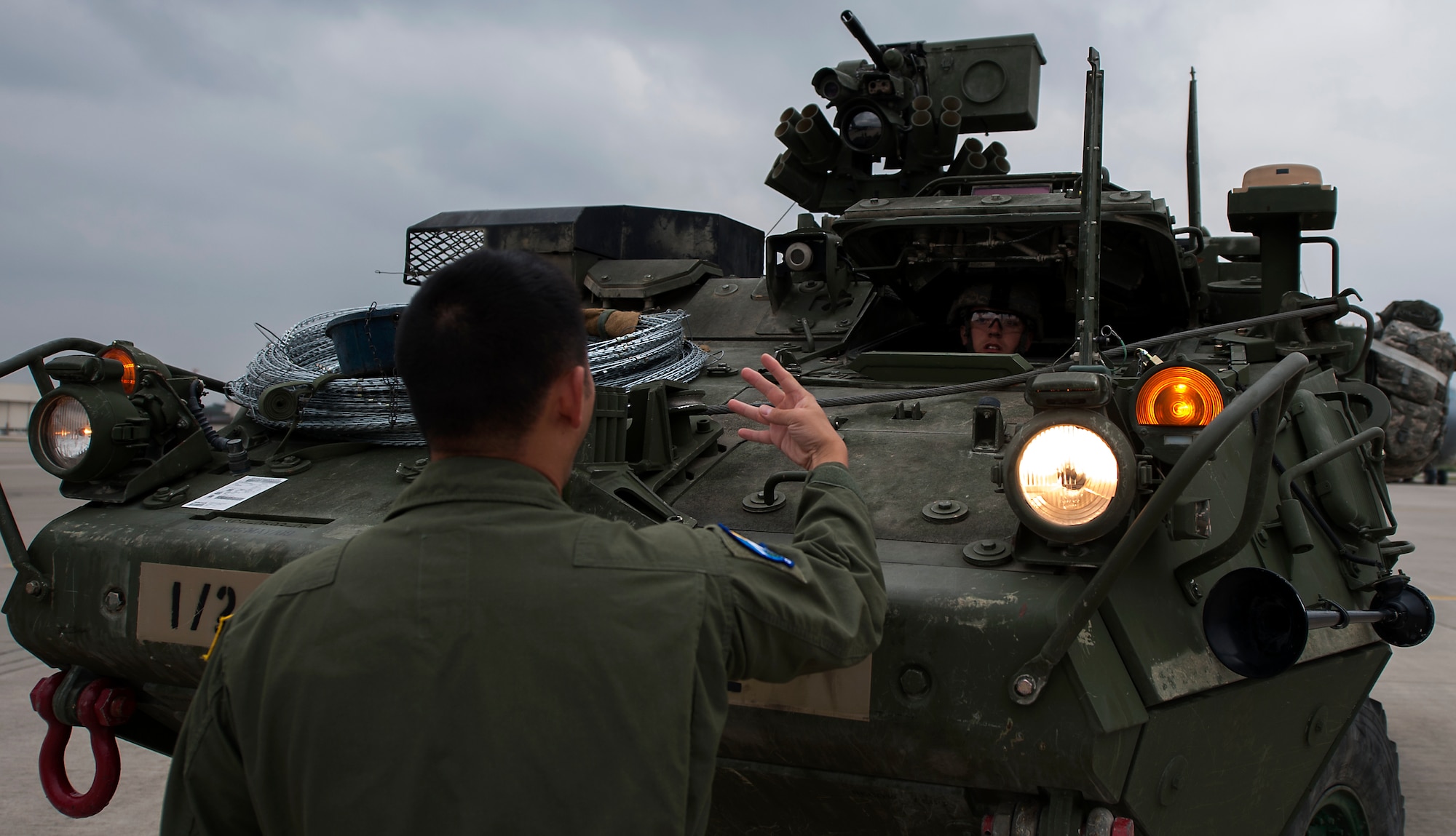 Staff Sgt. Quan Vu, 7th Airlift Squadron loadmaster, instructs Army Private 1st Class Austin Hurrelbrink, 2nd Cavalry Regiment soldier, on proper procedures of loading a Stryker into a C-17 Globemaster III in support of Steadfast Javelin II on Ramstein Air Base, Germany, Sept. 2, 2014. (U.S. Air Force photo/Senior Airman Damon Kasberg)