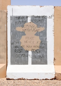 A T-wall painted in honor of Air Force Staff Sgt. Jerome Dominguez protects members of the 105th Security Forces Squadron who are deployed to Joint Base Balad, Iraq, with the 532nd Expeditionary Security Forces Squadron. Dominguez, who was a security forces member with the 105th SFS, sacrificed his life during the 9/11 attacks at the World Trade Center to help others.