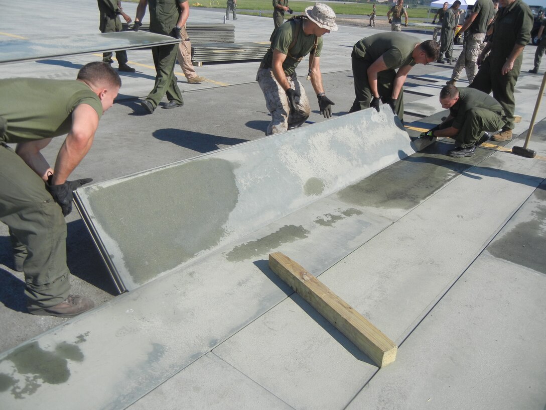 Marines from Marine Corps Air Station, Expeditionary Airfields, Marine Wing Support Squadron 274 put down new AM-2 matting on the Delta taxiway at Quantico’s Marine Corps Air Facility on Aug. 26.