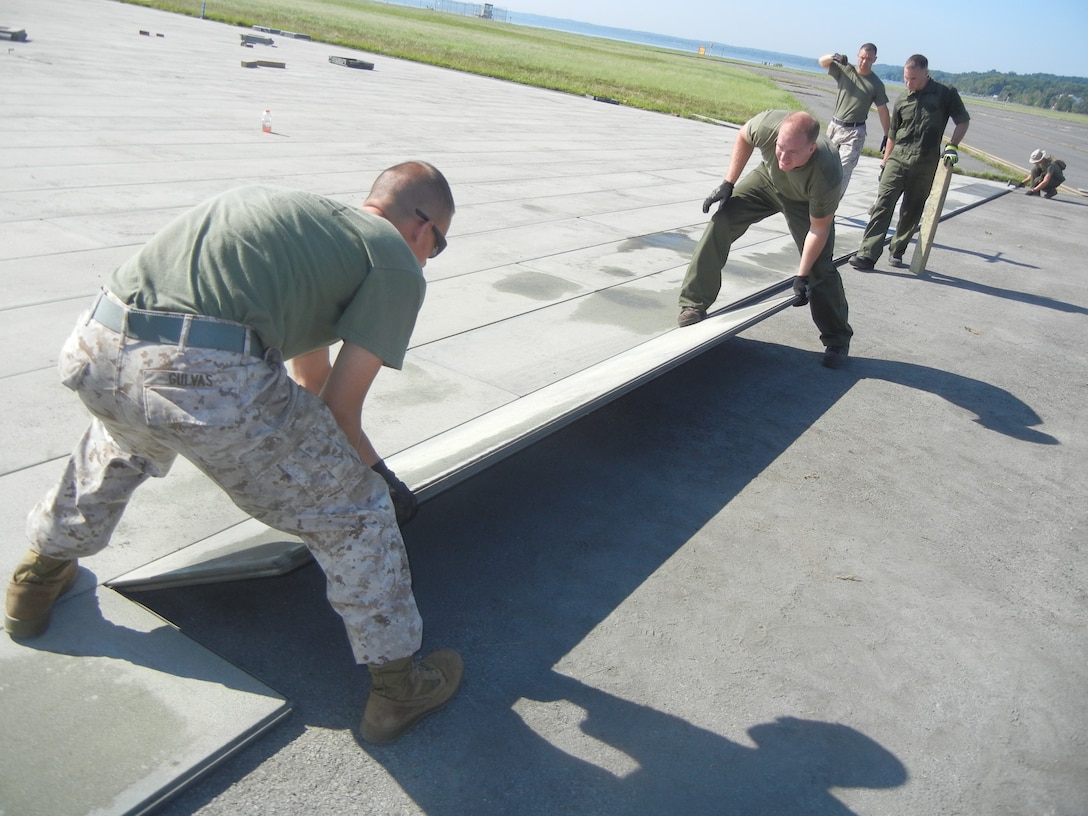 Marines from Marine Corps Air Station, Expeditionary Airfields, Marine Wing Support Squadron 274 put down new AM-2 matting on the Delta taxiway at Quantico’s Marine Corps Air Facility on Aug. 26.