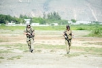 A member of the Kentucky Air National Guard's 123rd Special Tactics Squadron, right, teams up with his active duty counterpart to establish a relief supply drop zone near Port au Prince, Haiti.