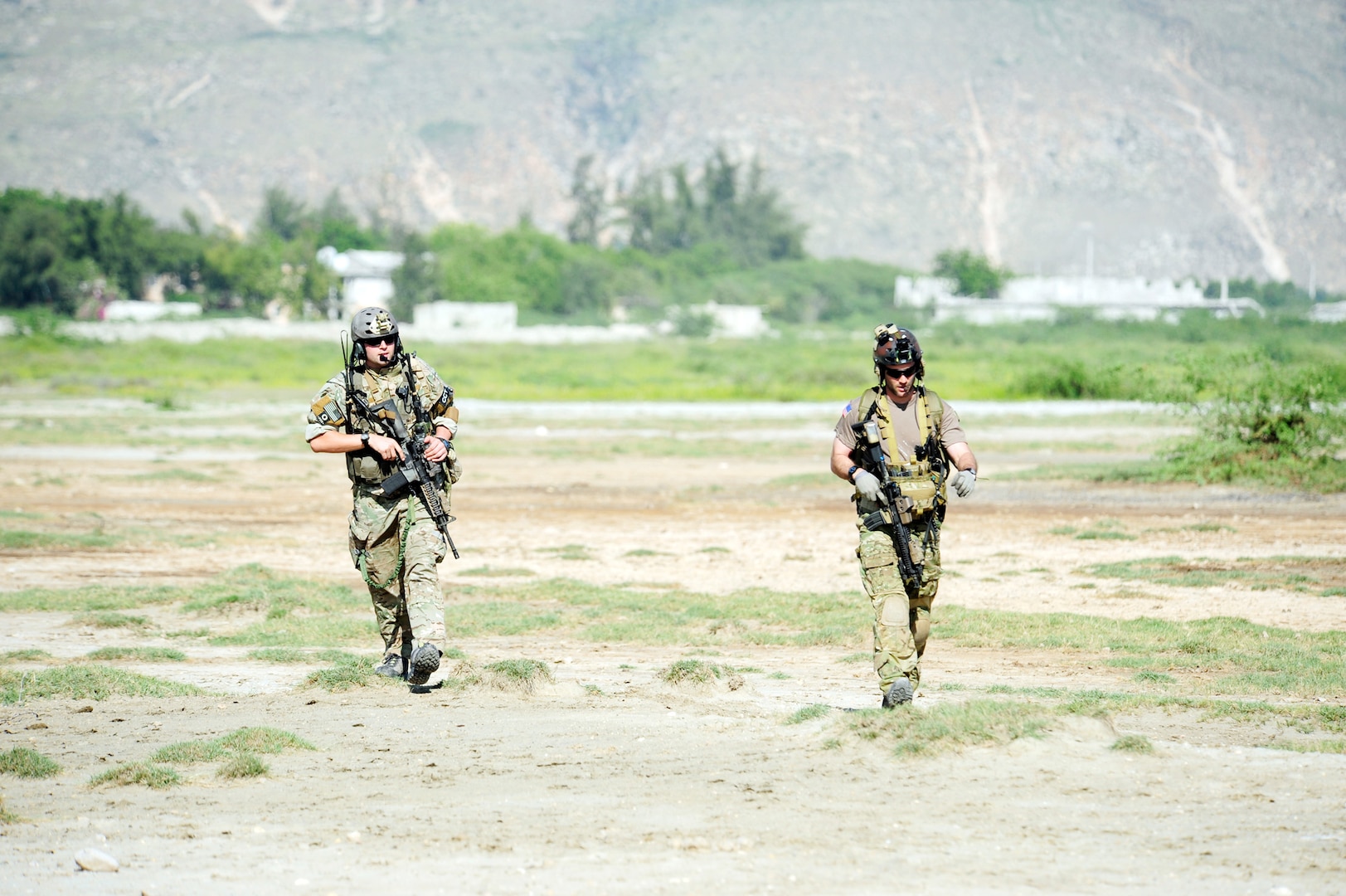 A member of the Kentucky Air National Guard's 123rd Special Tactics Squadron, right, teams up with his active duty counterpart to establish a relief supply drop zone near Port au Prince, Haiti.