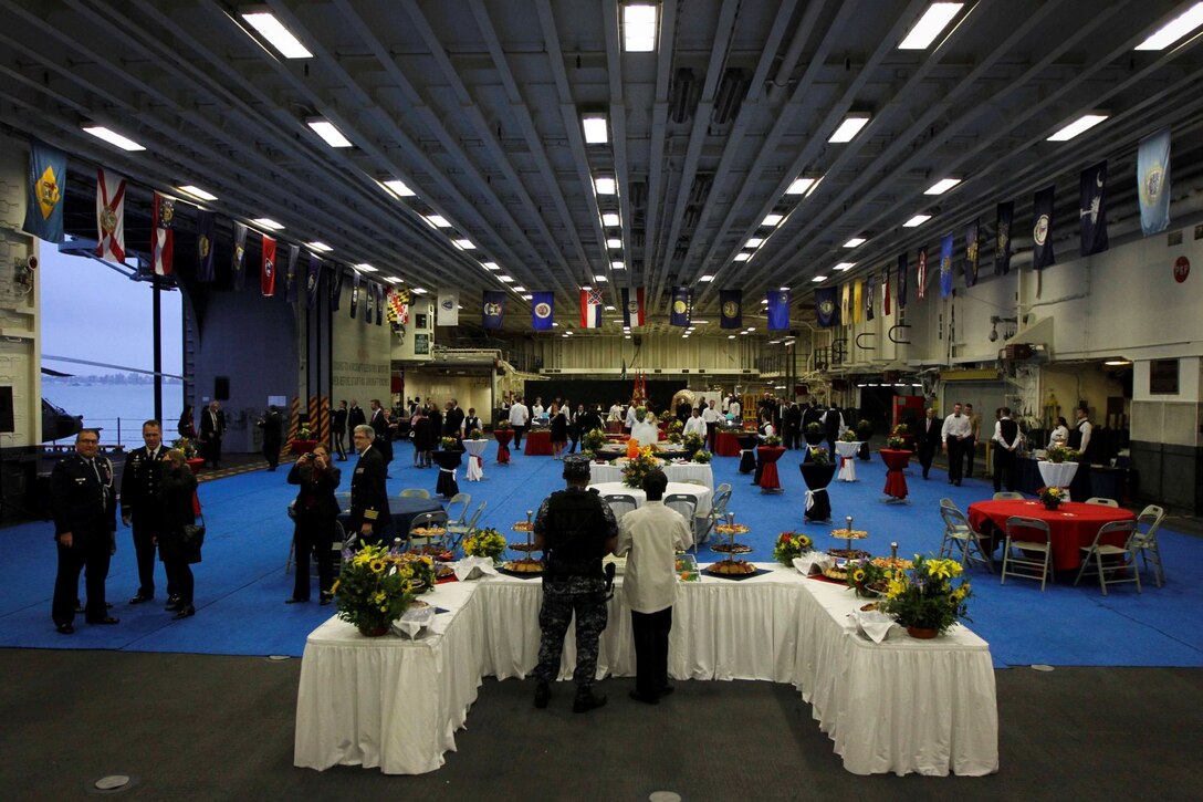 Peruvian distinguished guests are hosted for an evening reception in the hangar bay of the future amphibious assault ship USS America (LHA 6), Sept. 1, 2014. The reception was hosted by the Marines, Sailors aboard the ship and U.S. Ambassador to Peru Brian A. Nichols. The formal evening consisted of food, music and dancing, concluding with the presentation of the colors and speeches from Rear Adm. Frank L. Ponds, commander of Expeditionary Strike Group 3, and Ambassador Nichols. Marines and Sailors with Special Purpose Marines Air Ground Task Force South are currently embarked aboard America in support of her maiden transit, "America Visits the Americas." The transit is a clear example of our nation's commitment to our regional partners and allies. (U.S. Marine Corps Photo by Cpl. Donald Holbert/ Released)