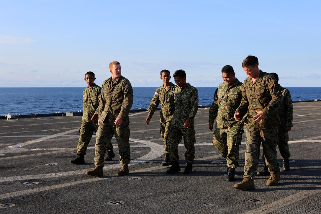 Marines with Echo Company, Battalion Landing Team 2nd Battalion, 1st Marines, 11th Marine Expeditionary Unit, give members of the Malaysian Armed Forces a tour of the USS Comstock during Malaysia-United States Amphibious Exercise 2014 Aug. 30. MALUS AMPHEX 14 is a bilateral exercise between the 11th MEU and Malaysian Armed Forces that includes operational and tactical level training in planning, command and control, and combat service support using both ground and sea assets. (U.S. Marine Corps photo by Sgt. Melissa Wenger/Released)