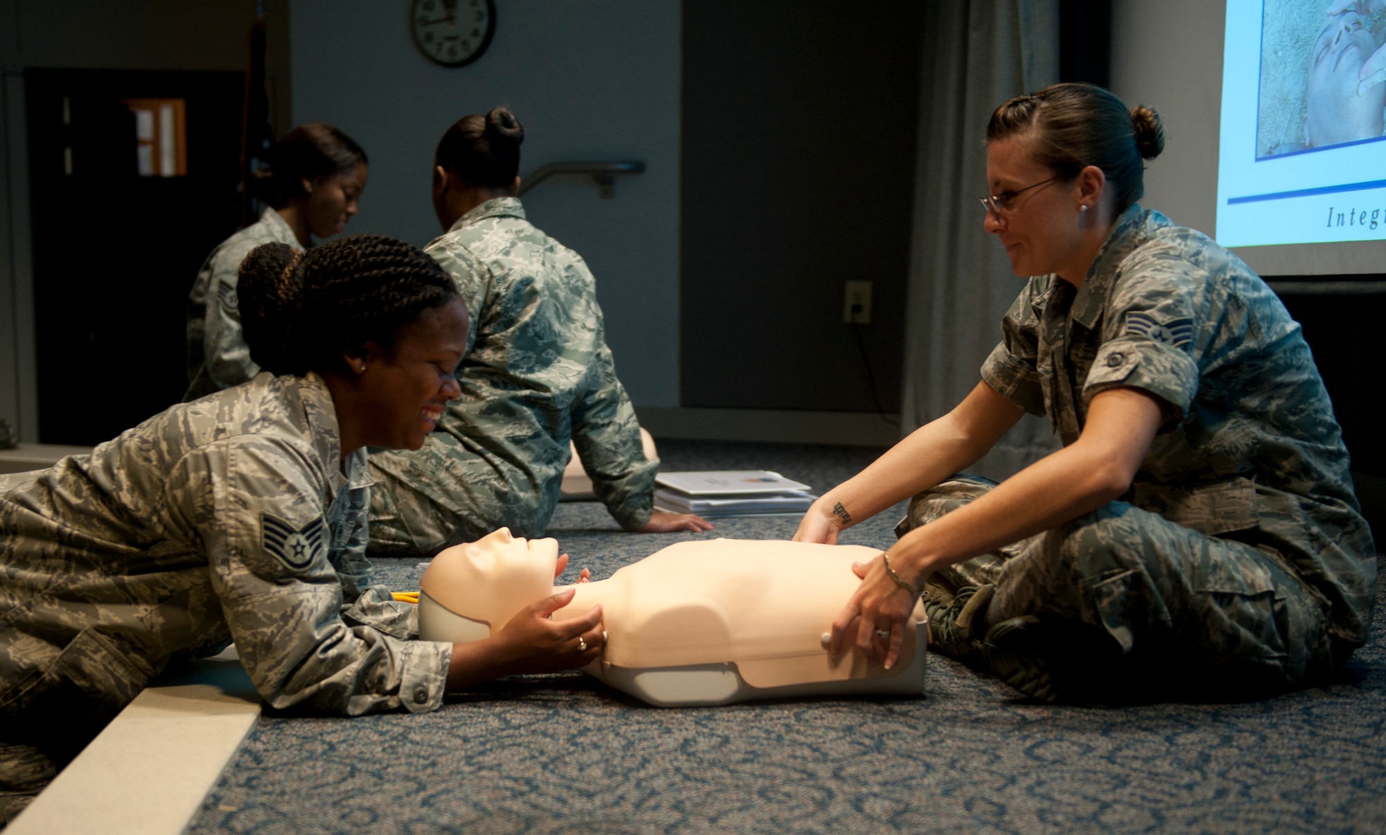 Senior Airman Austin Olin and Airman 1st Class Javiann Ayala, 1st Special Operations Security Forces Squadron patrolmen, demonstrate the proper way to apply a bandage wrap during a Self-Aid Buddy Care instructor course at Hurlburt Field, Fla., Sept. 4, 2014. Airmen learned different techniques to control bleeding during the course. (U.S. Air Force photo/Senior Airman Krystal M. Garrett) 