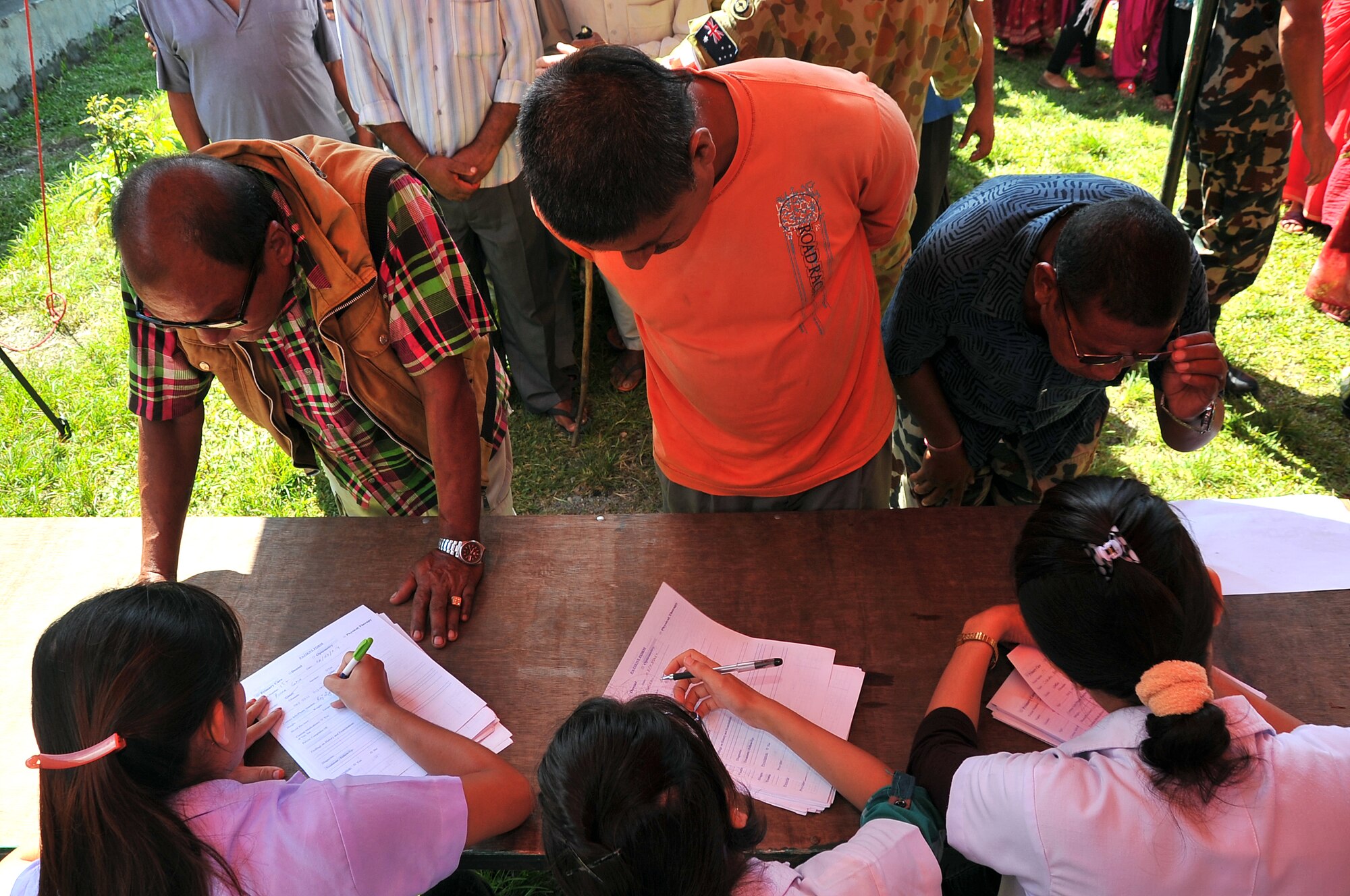 Local nursing students assist the first Operation Pacific Angel-Nepal patients in filling out information sheets at a health services outreach site in Manahari, Nepal, Sept. 8, 2014. PACANGEL supports U.S. Pacific Command’s capacity-building efforts by partnering with other governments, non-governmental agencies and multilateral militaries in the respective region to provide medical, dental, optometry and engineering assistance to their citizens. (U.S. Air Force photo by Staff Sgt. Melissa B. White/Released)