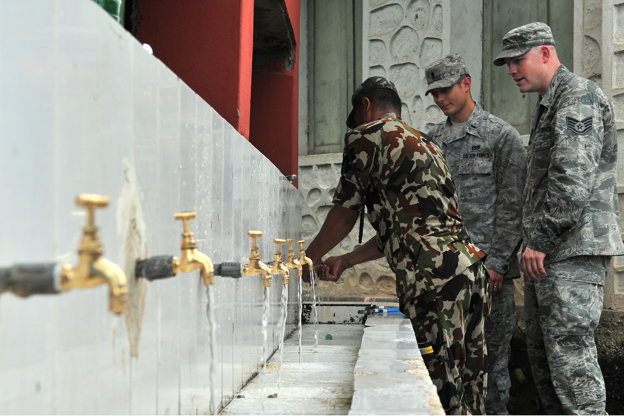 U.S. Air Force Airmen and a Nepalese Army Soldier work together to repair water fixtures at a school in Manahari, Nepal, Sept. 7, 2014, for Operation Pacific Angel-Nepal. PACANGEL supports U.S. Pacific Command’s capacity-building efforts by partnering with other governments, non-governmental agencies and multilateral militaries in the respective region to provide medical, dental, optometry and engineering assistance to their citizens. (U.S. Air Force photo by Staff Sgt. Melissa B. White/Released)