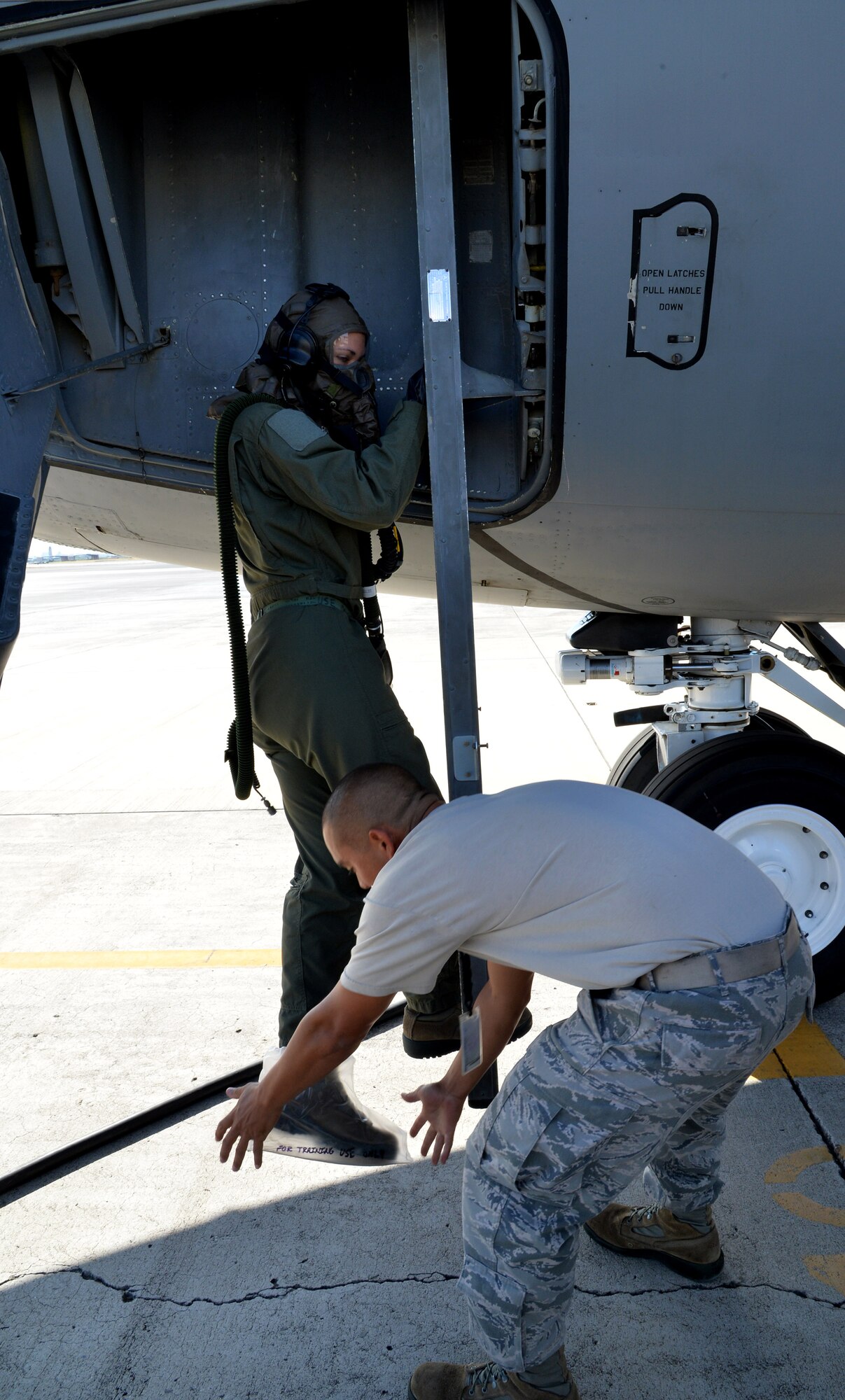 Airman 1st Class Rebekah McCormack, 96th Air Refueling Squadron, climbs aboard a KC-135 Stratotanker while being assisted by a maintenance technician during an emergency preparedness training event Sept. 5, 2014, at Joint Base Pearl Harbor-Hickam, Hawaii. McCormack and other 96th ARS members participated in the chemical, biological, radiological and nuclear training that ensures they are prepared to operate in a contaminated environment. Note: In a real-world CBRN environment, the maintenance technician would also be in individual protective equipment. (U.S. Air Force photo by Staff Sgt. Alexander Martinez)