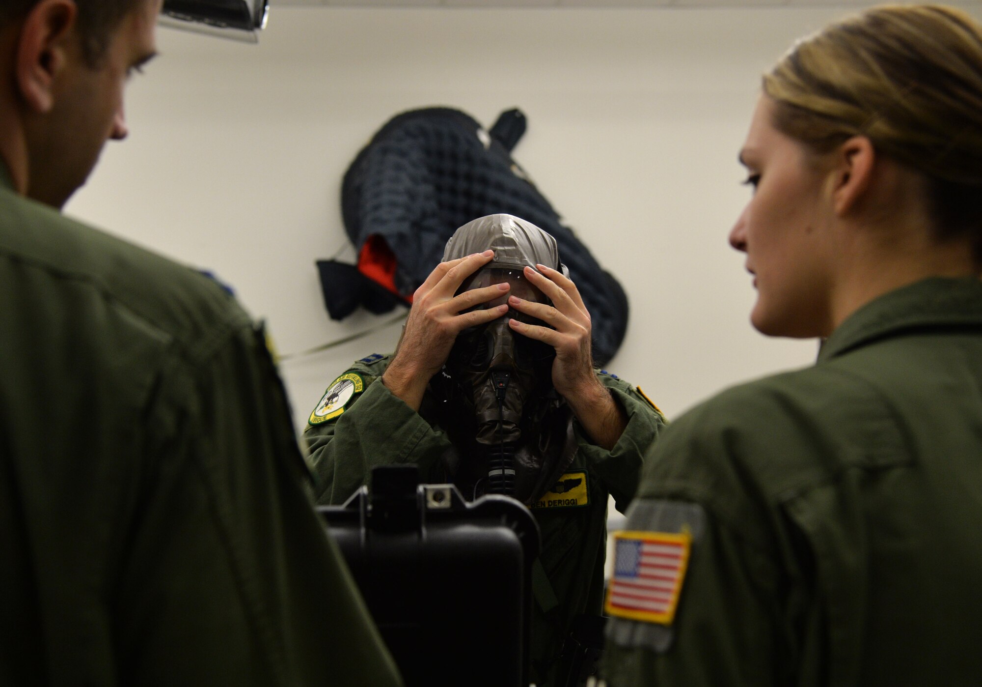 Capt. Benjamin Deriggi, 96th Air Refueling Squadron, puts on the hood and gasmask portion of an Aircrew Eye and Respiratory Protection System during an emergency preparedness training event Sept. 5, 2014, at Joint Base Pearl Harbor-Hickam, Hawaii. Deriggi and other 96th ARS members participated in the chemical, biological, radiological and nuclear training that ensures they are prepared to operate in a contaminated environment. (U.S. Air Force photo by Staff Sgt. Alexander Martinez)