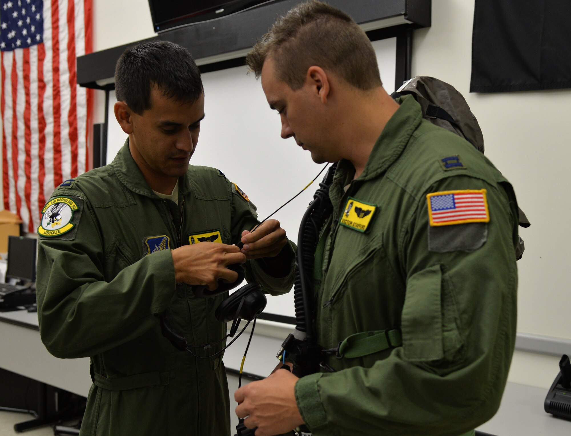 Capt. Daniel Montilla (left), 96th Air Refueling Squadron, assists Capt. Victor Stafford, 96th ARS, with putting on an Aircrew Eye and Respiratory Protection System during an emergency preparedness training event Sept. 5, 2014, at Joint Base Pearl Harbor-Hickam, Hawaii. Montilla, Stafford and other 96th ARS members participated in the chemical, biological, radiological and nuclear training that ensures they are prepared to operate in a contaminated environment. (U.S. Air Force photo by Staff Sgt. Alexander Martinez)