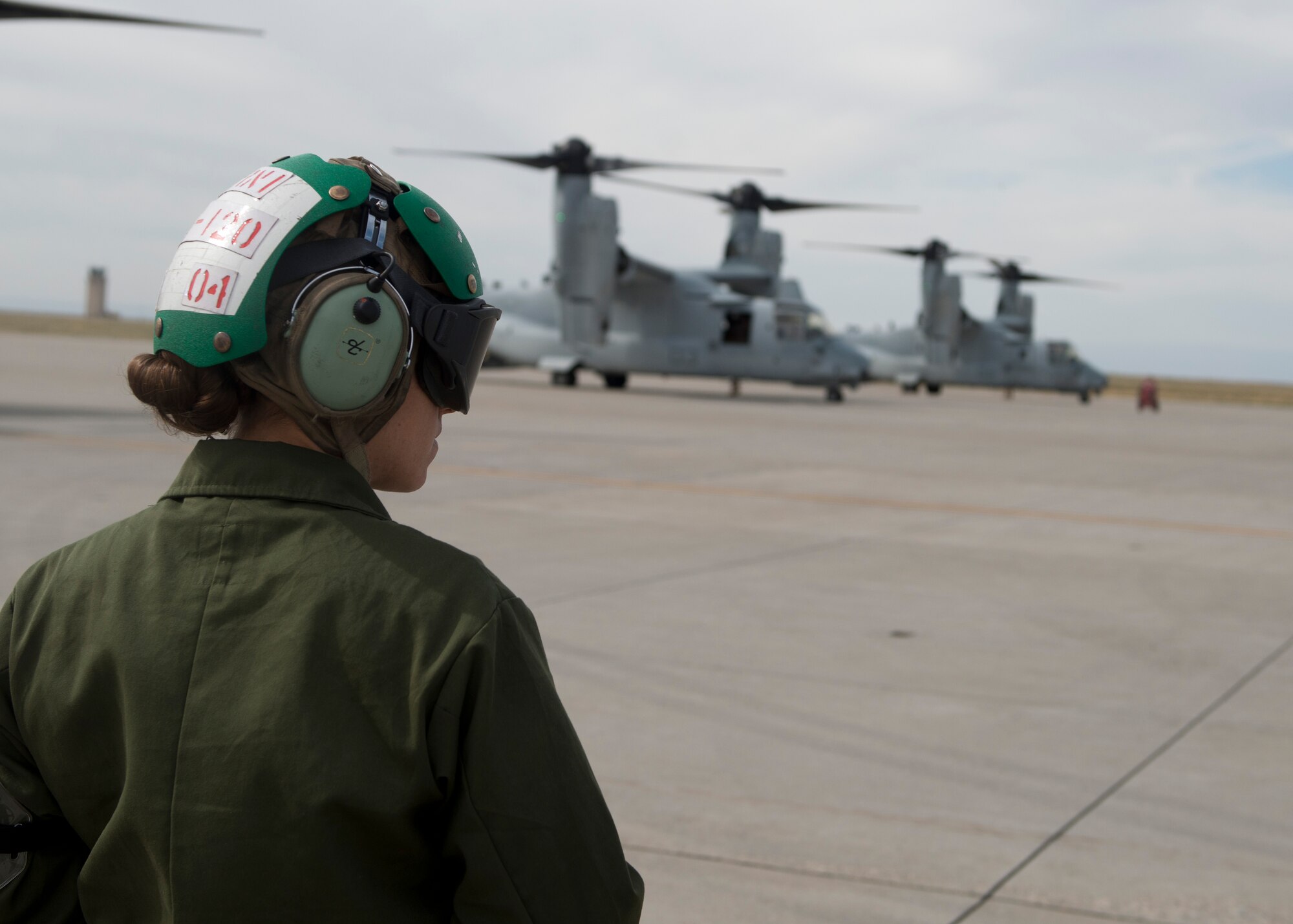 A crew member from the Marine Medium Tiltrotor Squadron 161, 3rd Marine Aircraft Wing, based out of Miramar, Calif., looks at multiple Ospreys before take-off from Mountain Home Air Force Base, Idaho, Sept. 8, 2014. The Ospreys crew members  conducted multiple operations throughout the day as part of combat training. (U.S. Air Force Photo by Airman 1st Class Brittany A. Chase/Released)