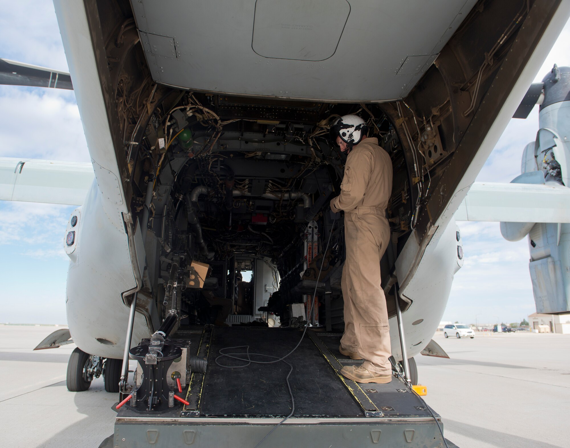 A crew member from the Marine Medium Tiltrotor Squadron 161, 3rd Marine Aircraft Wing, based out of Miramar, Calif.,inspects an Osprey before take off at Mountain Home Air Force Base, Idaho, Sept. 8, 2014. The Osprey's crew members  conducted multiple operations throughout the day as part of combat training. (U.S. Air Force Photo by Airman 1st Class Brittany A. Chase/Released)