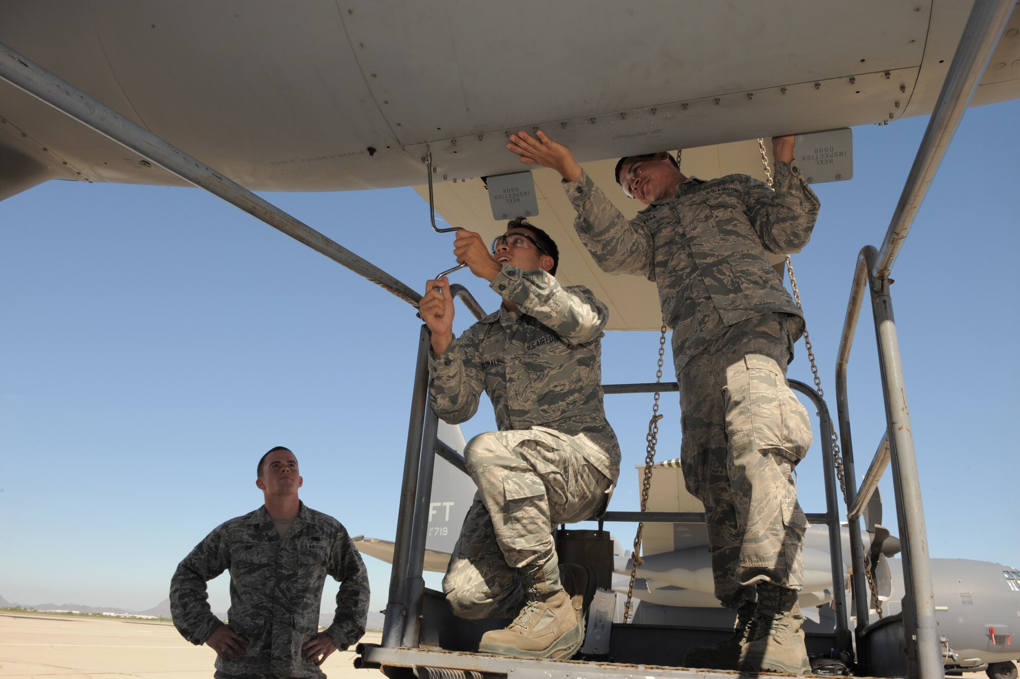Airmen from the 923rd Aircraft Maintenance Squadron replace a panel after inspecting the left-hand aerial refueling pod on a HC-130J at Davis-Monthan Air Force Base, Ariz., Sept. 5, 2014. Airmen 1st Class Tyler Ray, Jared Dumale and Michael Rivera were the first responders to an automobile accident involving four individuals Aug. 24. (U.S. Air Force photo by Airman 1st Class Chris Drzazgowski/Released) 