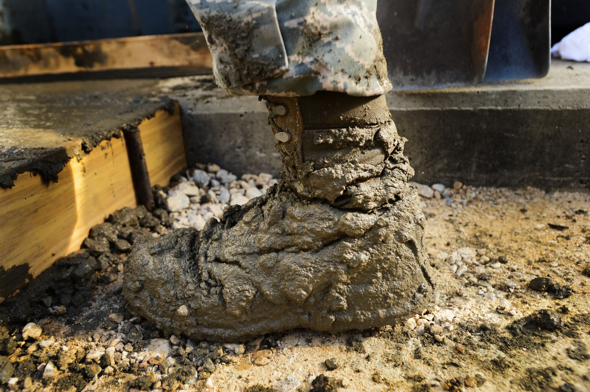 A 20th Civil Engineer Squadron Airman’s boots are covered in wet concrete after laying concrete behind Patton Hall at Shaw Air Force Base, S.C., Sept. 4, 2014. During the two week project, approximately 10 Airmen laid concrete around the four power generator units to provide a safer work environment for Airmen performing maintenance on the units. (U.S Air Force photo by Airman 1st Class Jensen Stidham/Released) 