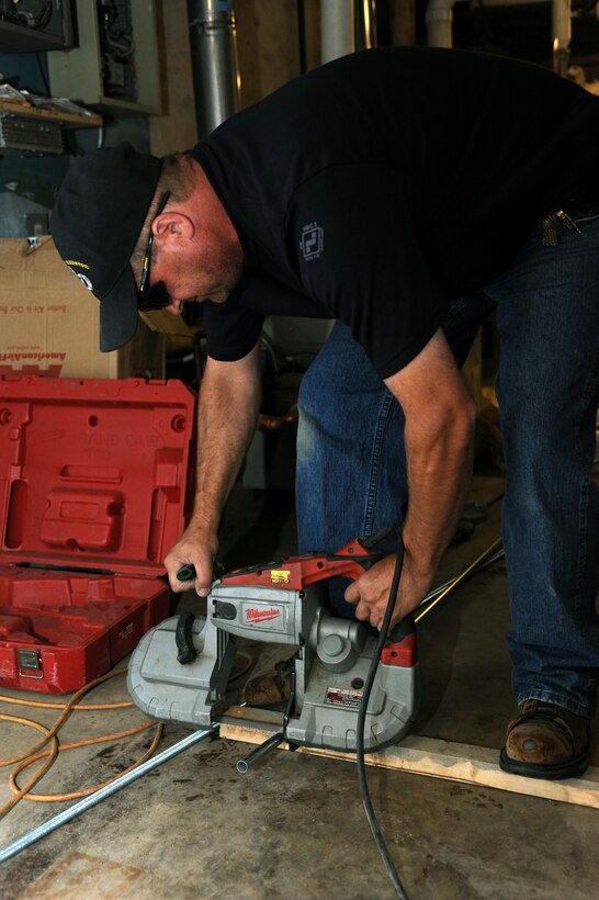 Eric Haakedal, 28th Civil Engineer Squadron Heating, Ventilation, Air Conditioning and Refrigeration technician, cuts an electrical wire conduit pipe during installation and maintenance of boilers used to heat buildings at Ellsworth Air Force Base, S.D., Sept. 4, 2014. Conduit keeps wires organized during the installation of equipment. (U.S. Air Force photo by Senior Airman Hailey R. Staker/Released)