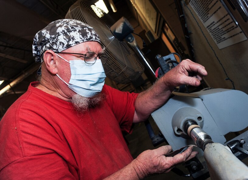 John Fischbach Sr., 23d Force Support Squadron recreation aide, polishes a bullet to be turned into a shot glass Aug. 8, 2014, at Moody Air Force Base, Ga. Fischbach usually works around 10 projects at any given time. (U.S. Air Force photo by Senior Airman Jarrod Grammel/Released)
