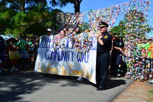 Out of the Darkness community walk participants pass through a curtain of 1,000 paper cranes at the start of the mental health awareness walk in Virginia Beach, Va., Sept. 6, 2014. According to the walk’s website, folding 1,000 paper cranes fulfills prayers for peace for those who died by suicide and those who suffer from depression. (U.S. Air Force photo by Senior Airman Aubrey White/Released)